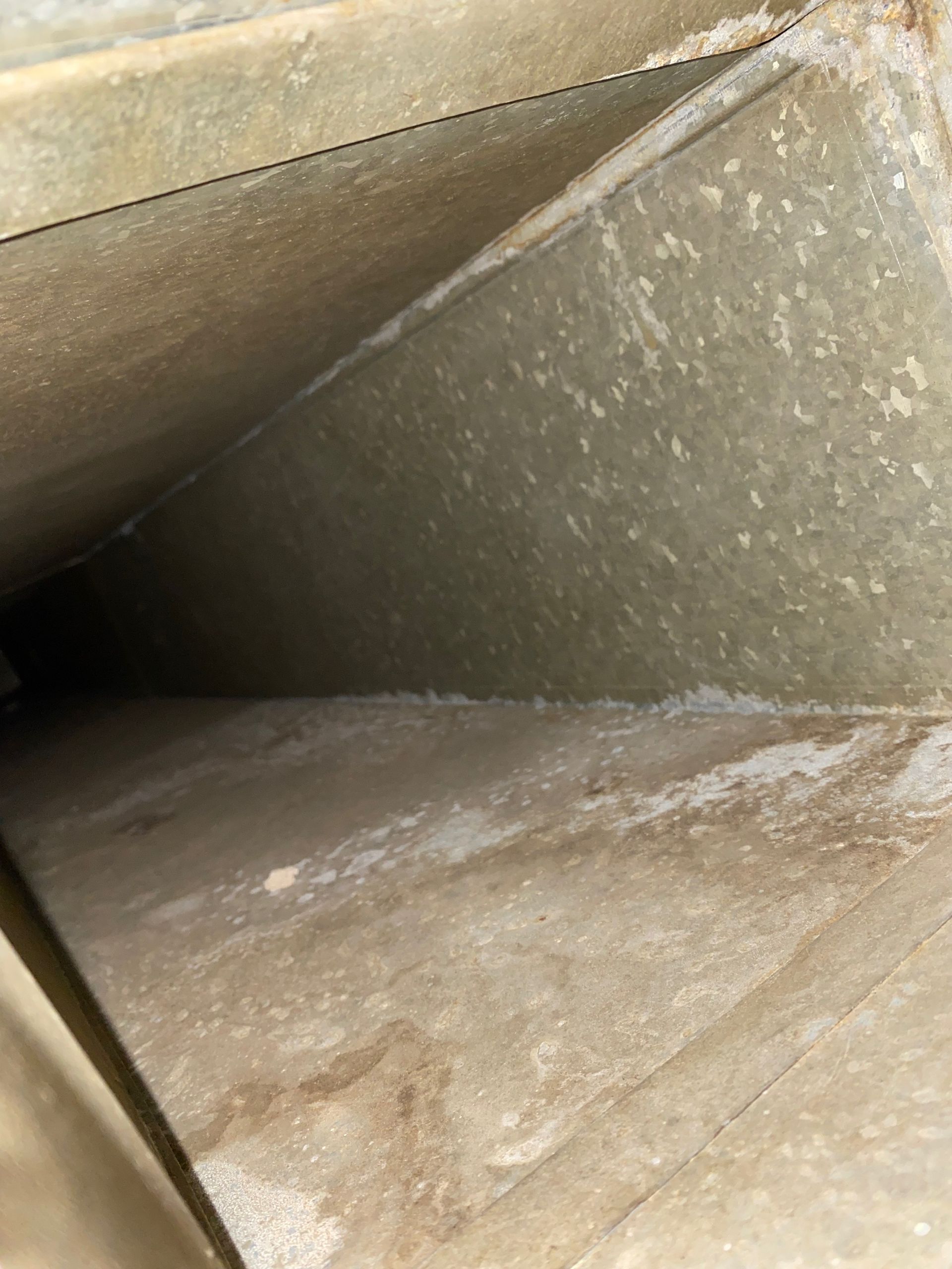 A close up of a dirty air vent in a building.