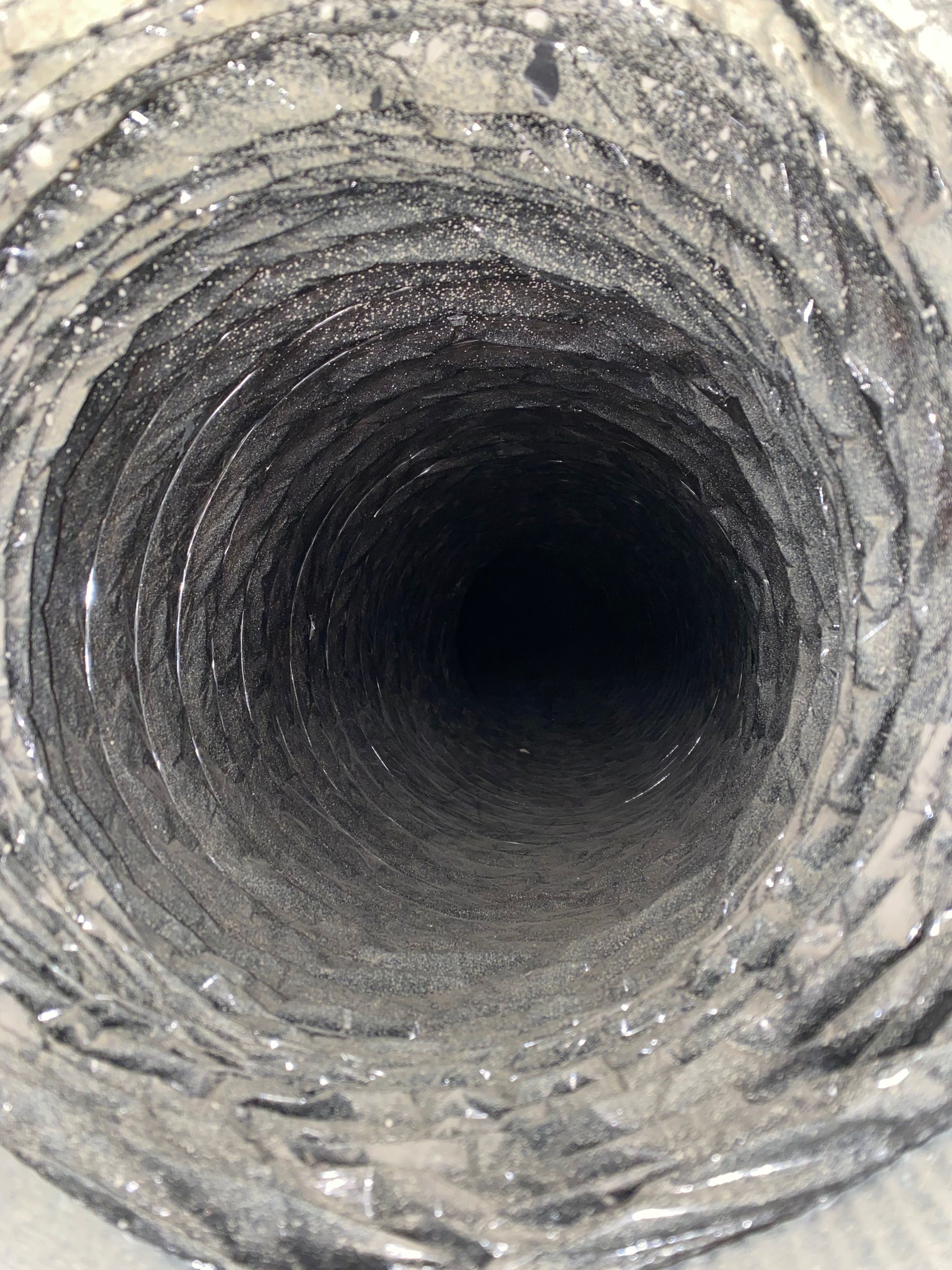 A close up of the inside of a duct that looks like a hole in the ground.