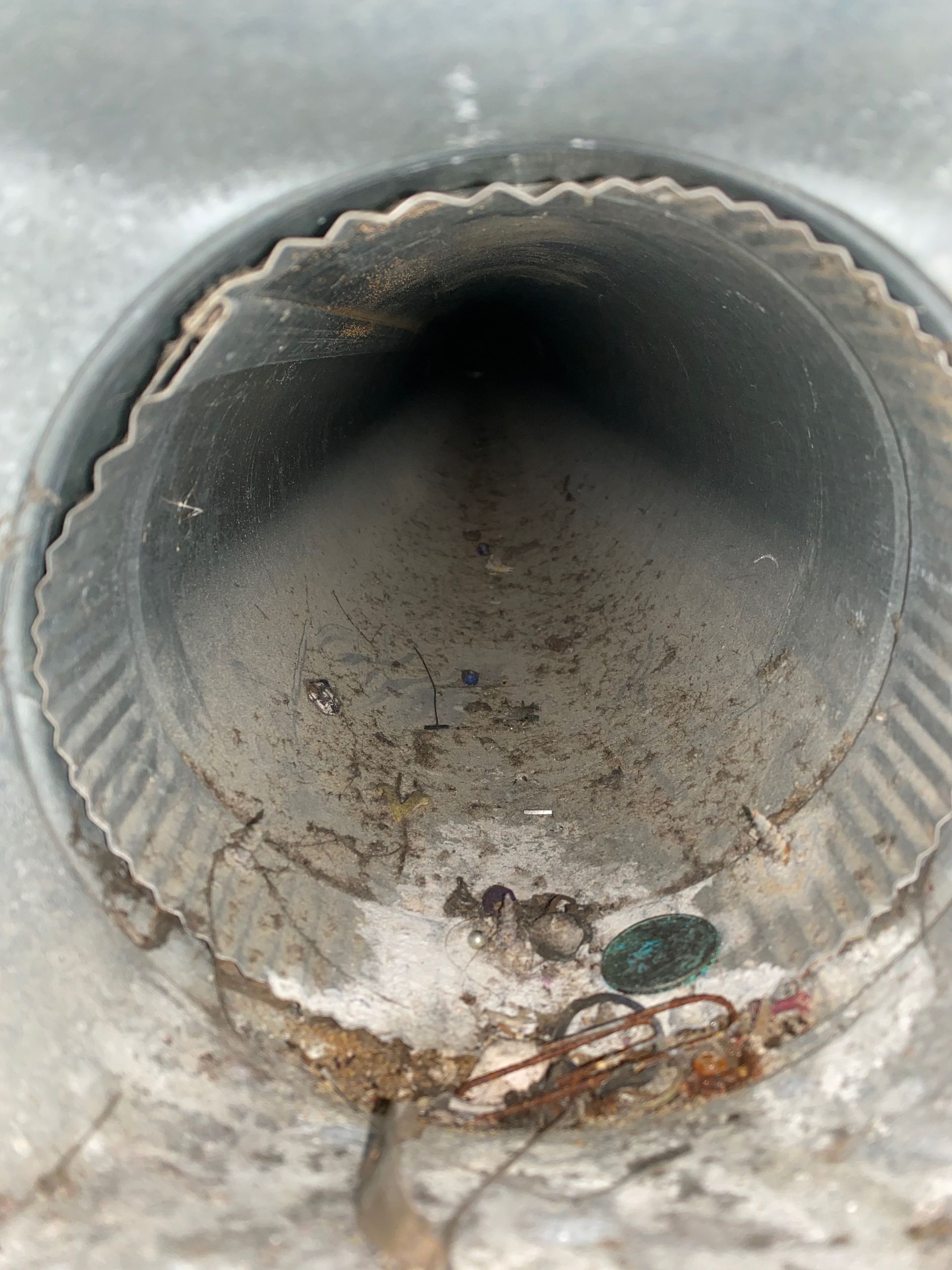 A dirty metal pipe with a hole in the middle