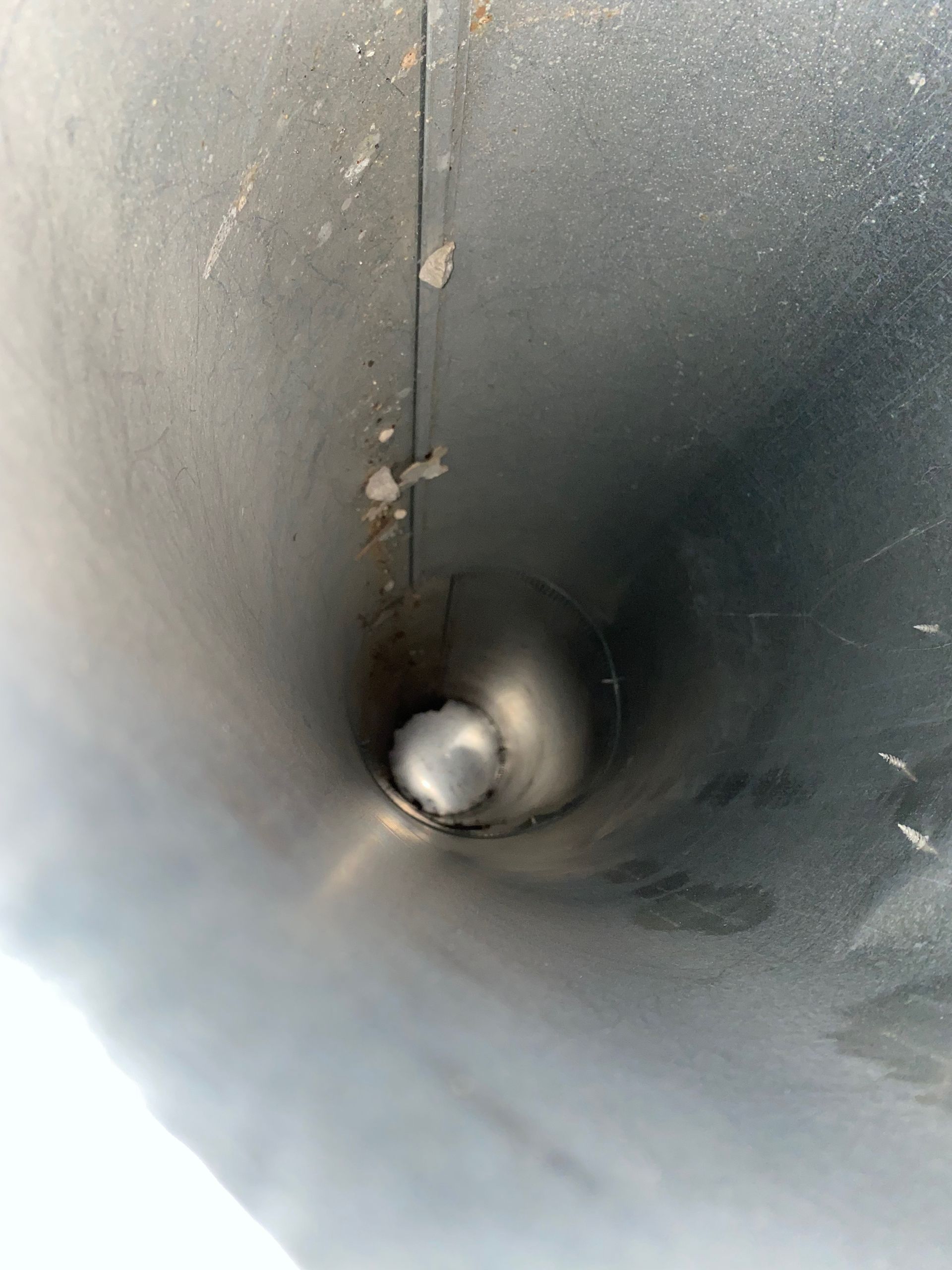 A close up of a metal pipe with a hole in the middle