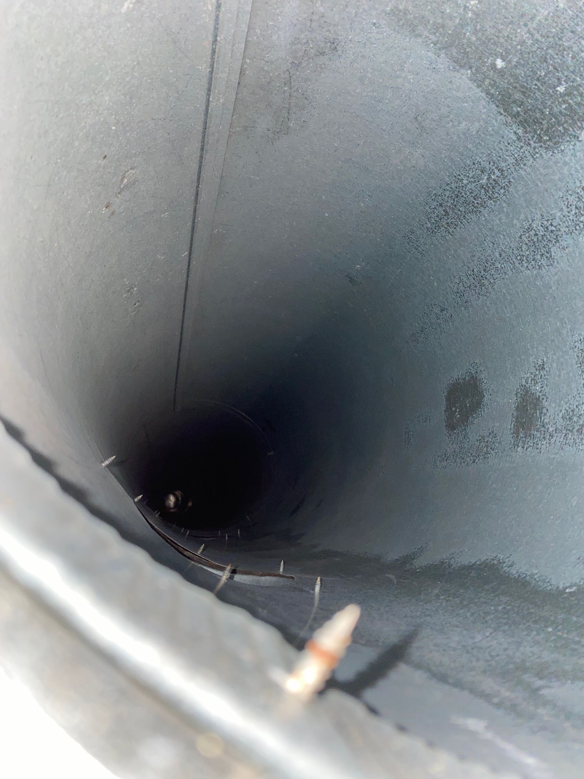 A close up of a black pipe with a hole in the middle