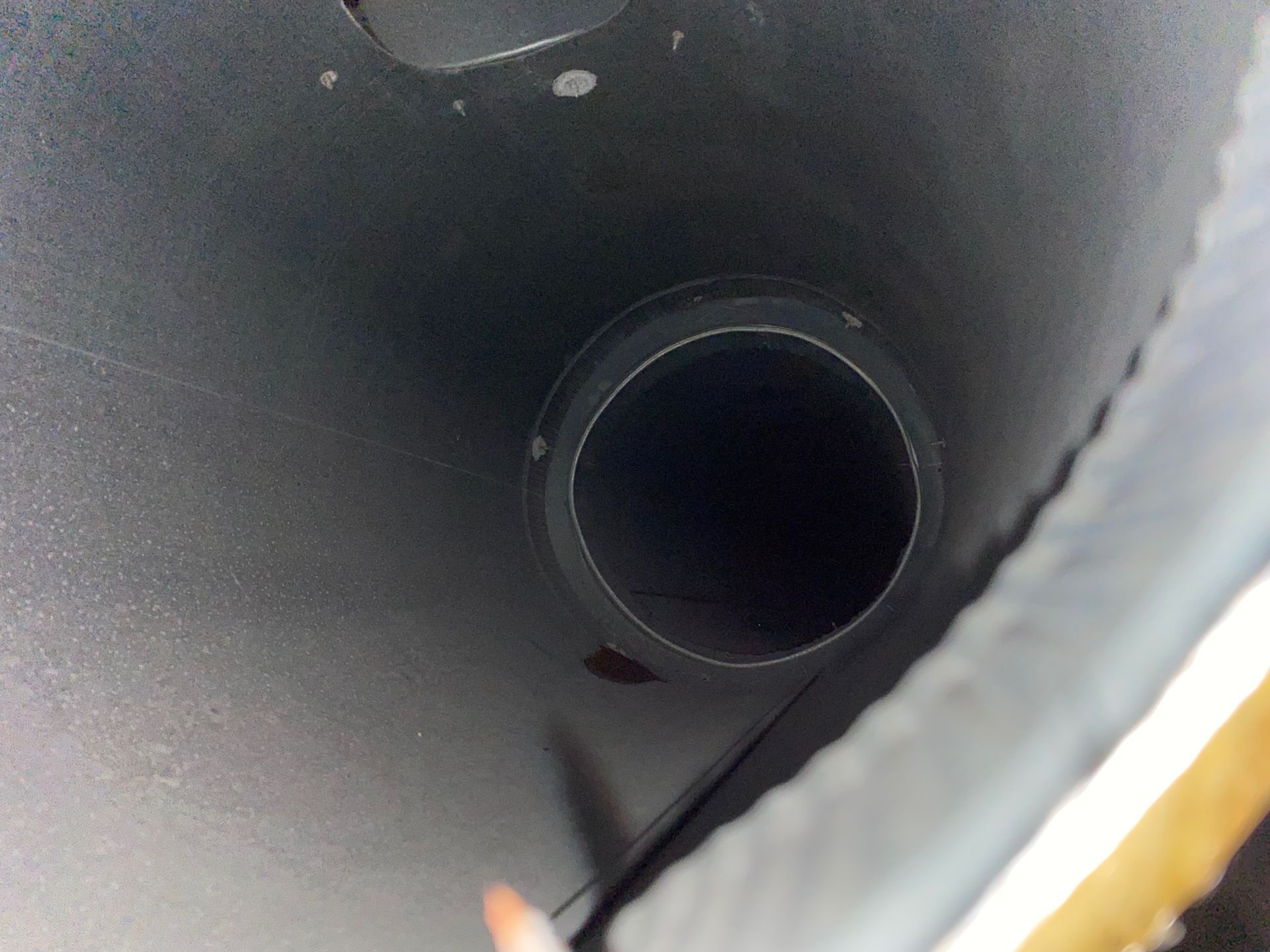 A close up of a black pipe with a hole in the middle