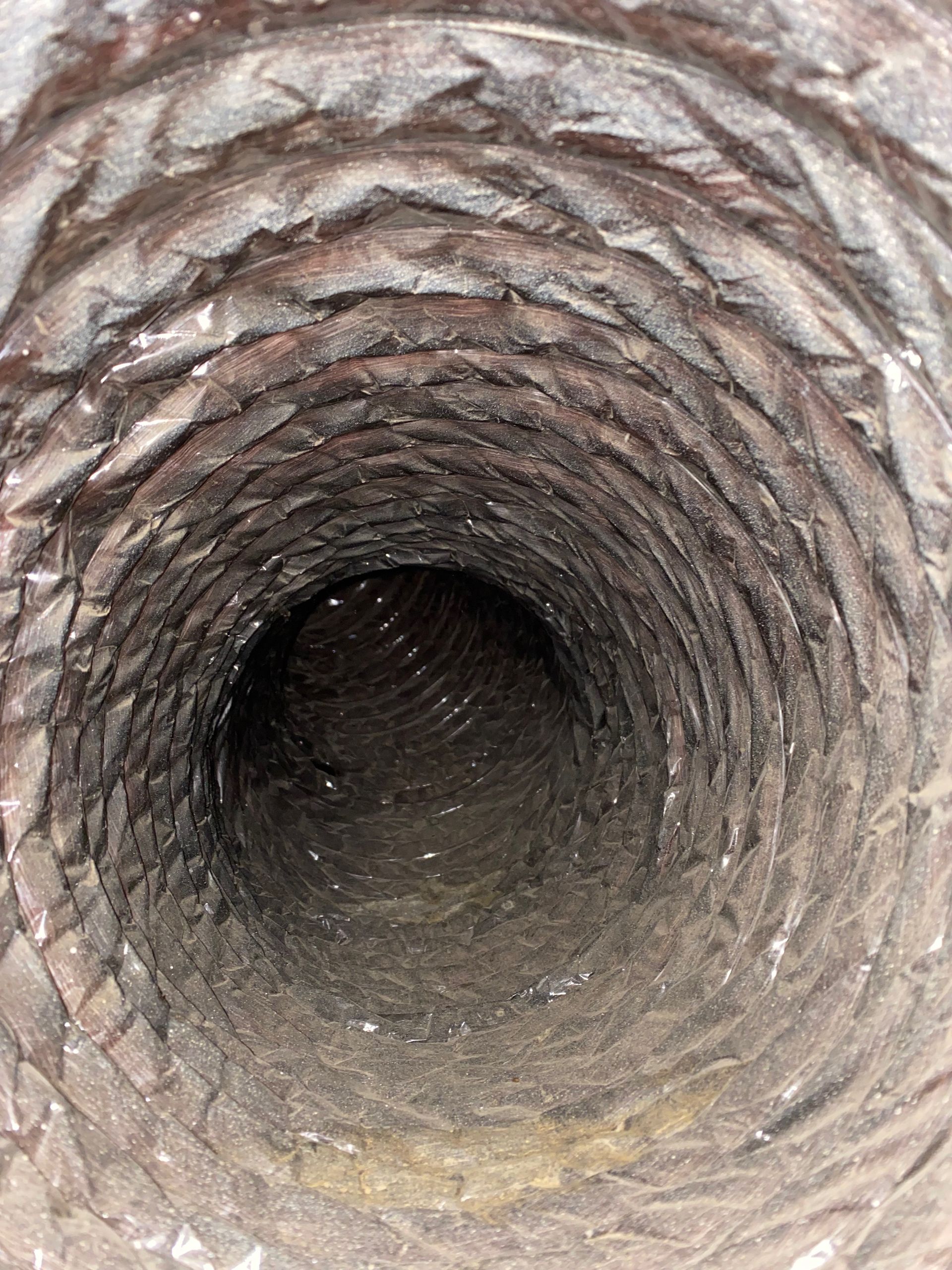 A close up of the inside of a dirty air duct.