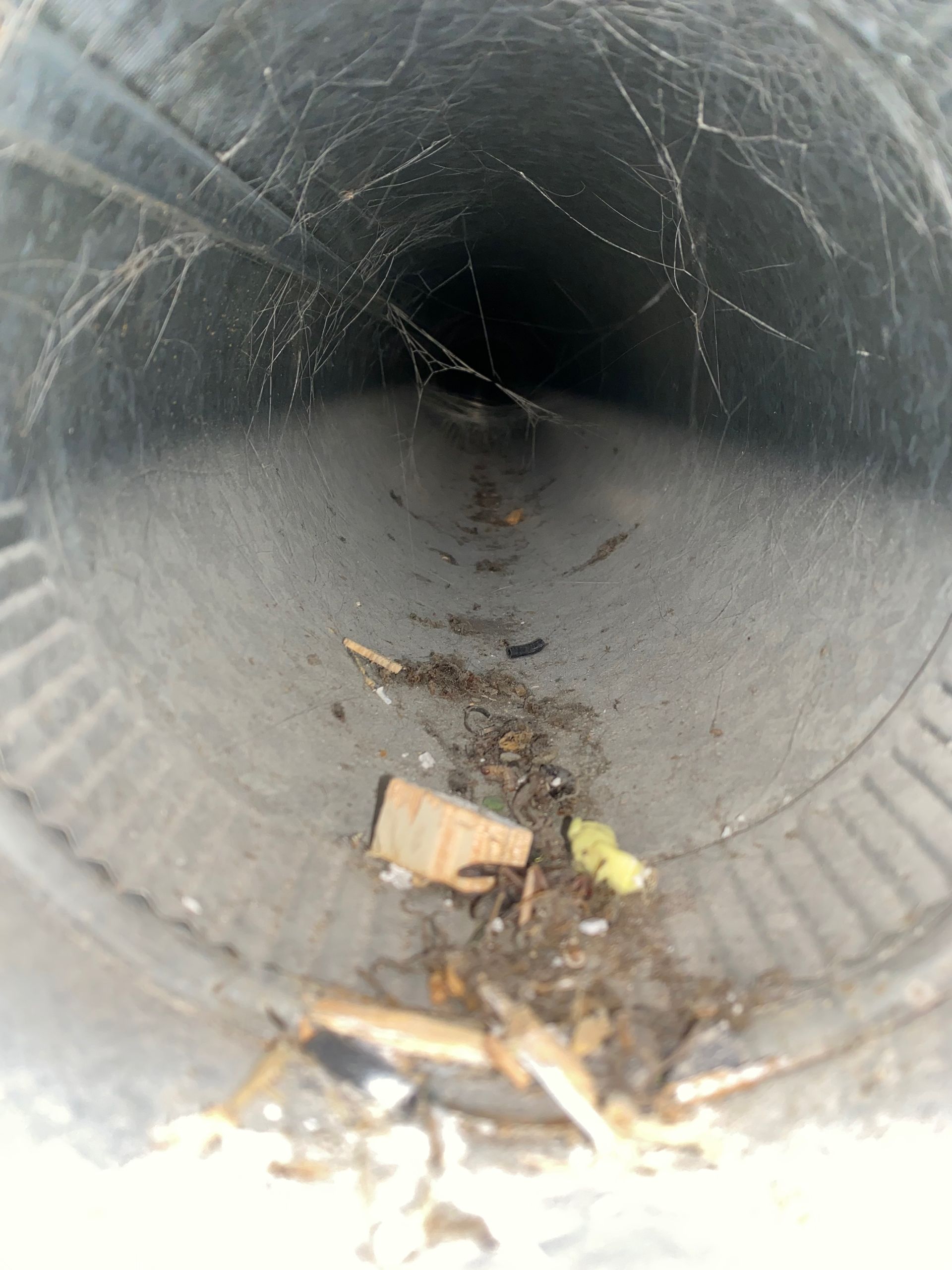 The inside of a pipe with a lot of trash in it