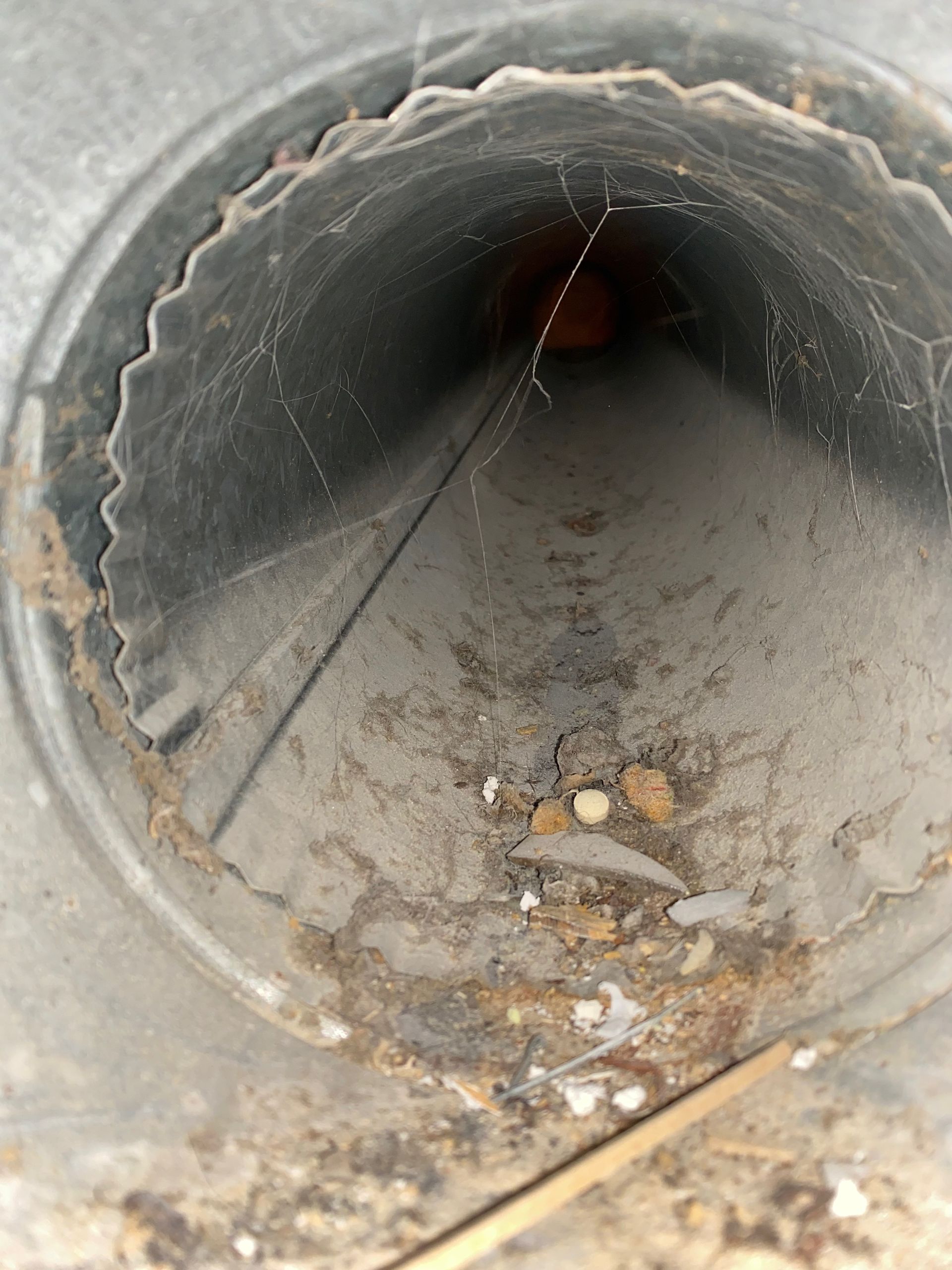 A dirty metal pipe with a hole in the middle