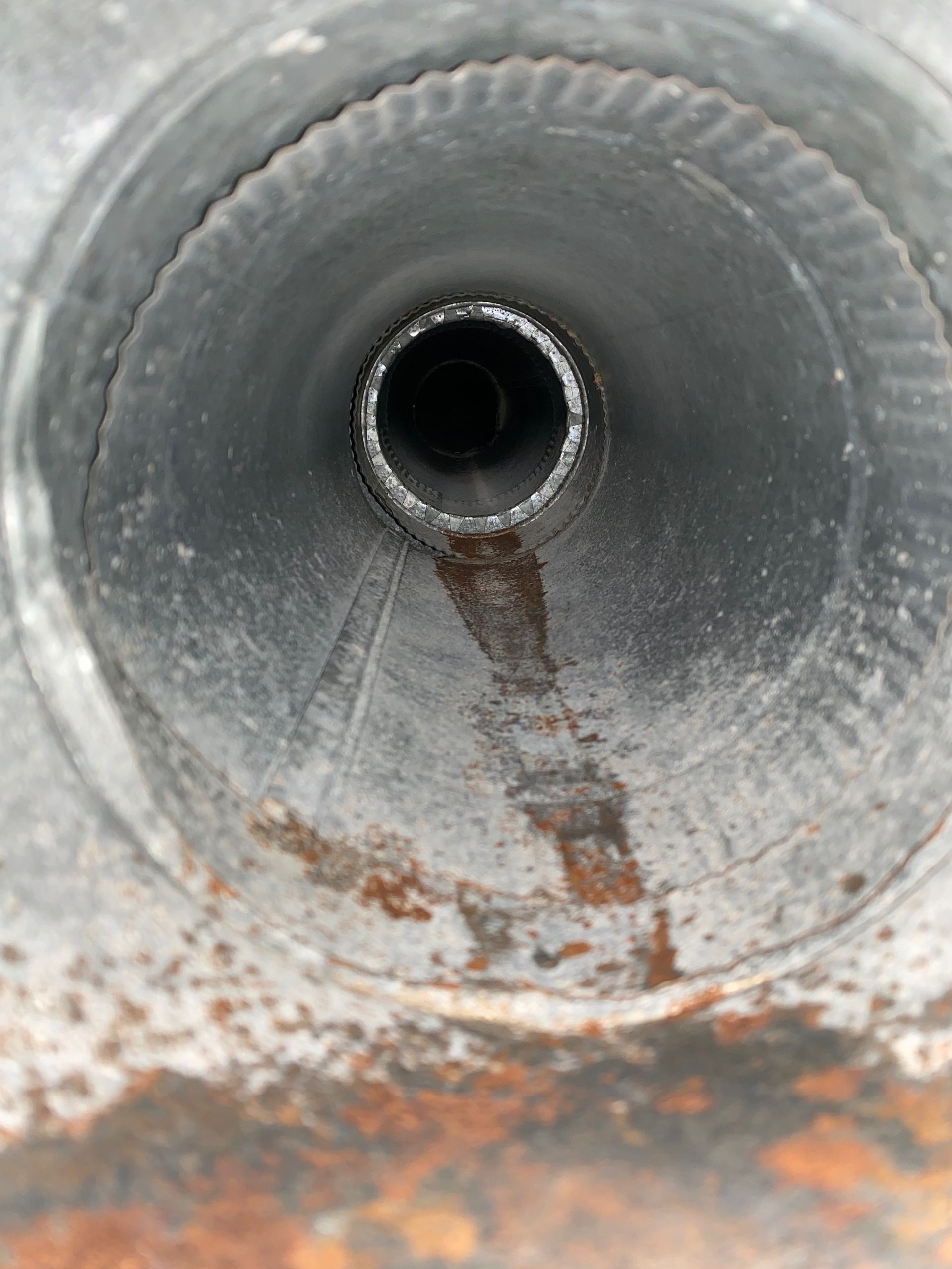 A close up of a metal pipe with a hole in the middle