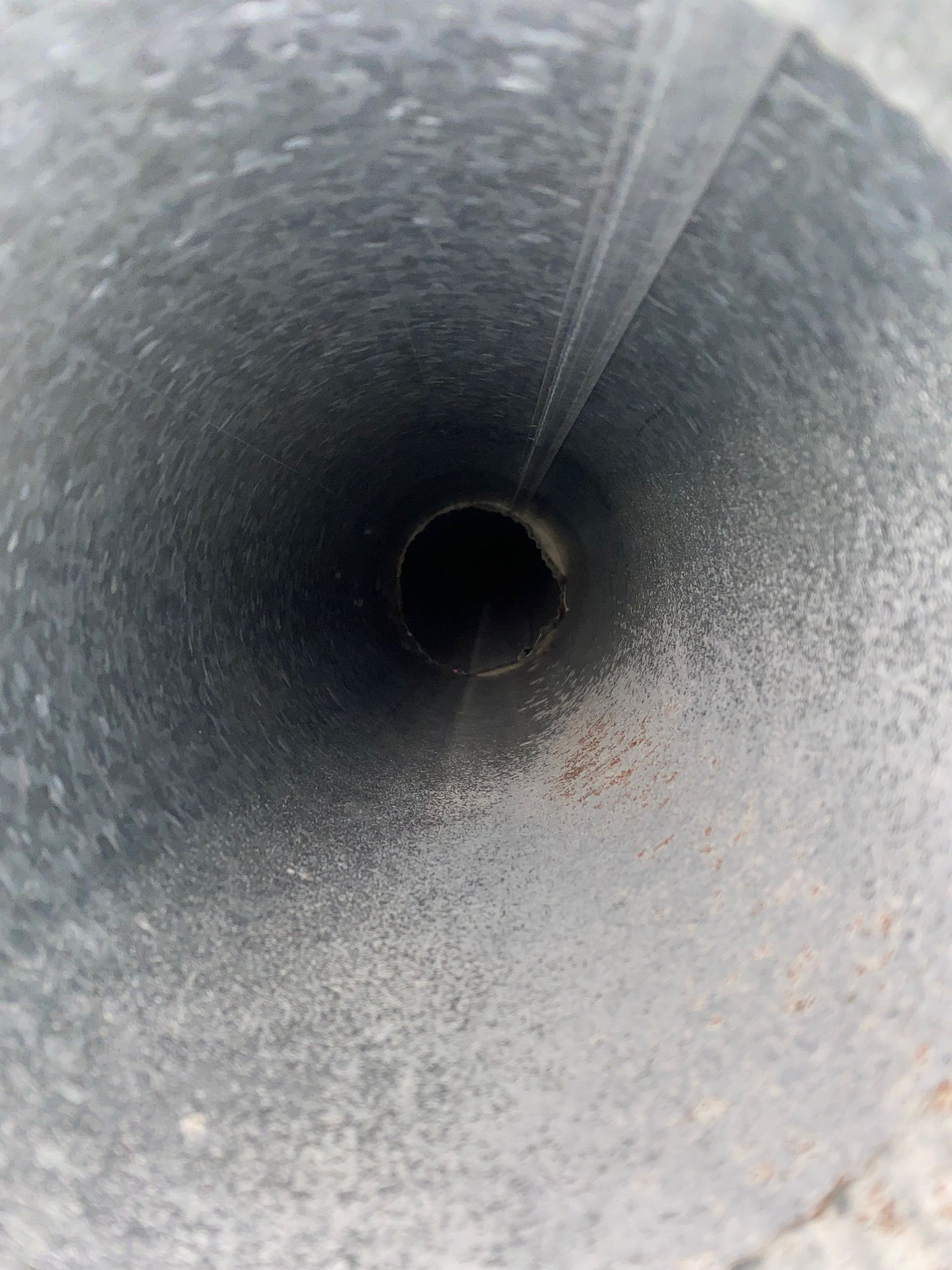 A close up of a metal pipe with a hole in the middle.