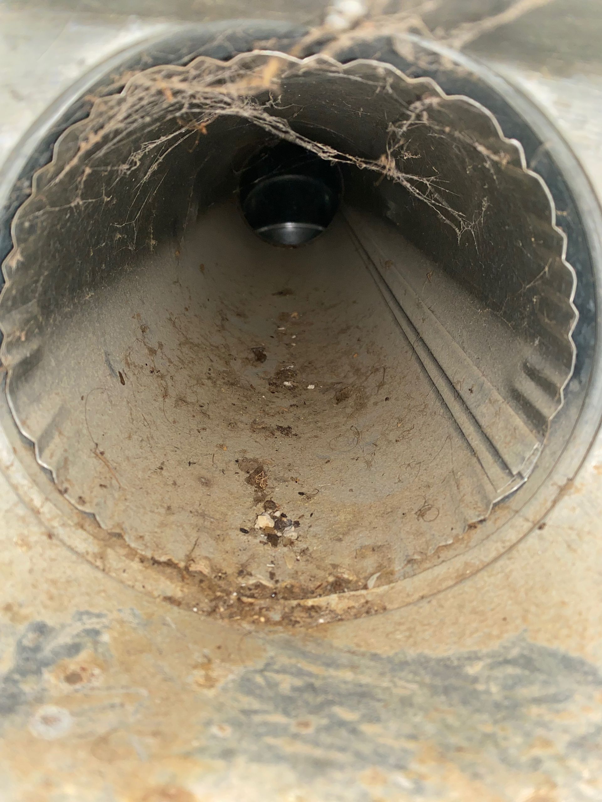 A dirty metal pipe with a hole in the middle