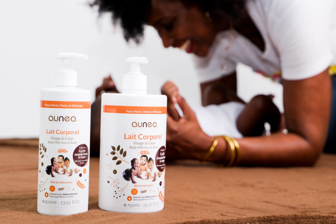 Deux bouteilles de lotion pour bébé, femme s'occupant d'un bébé, cadre marron.