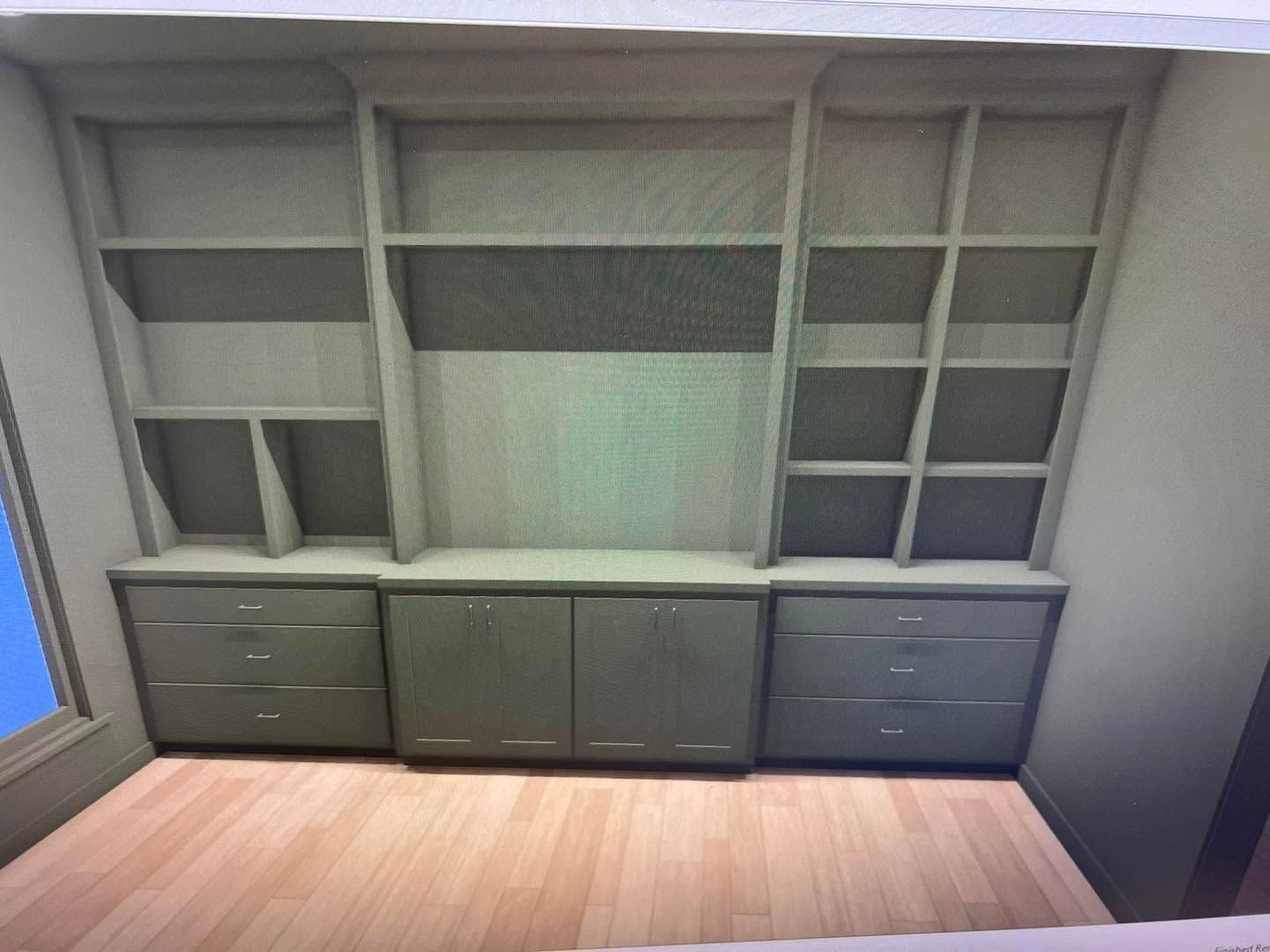 Built-in gray office wall unit with shelves, drawers, and cabinets above a wood floor