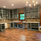 Built-in living room cabinetry with stone wall, hardwood floors, and chandelier lighting