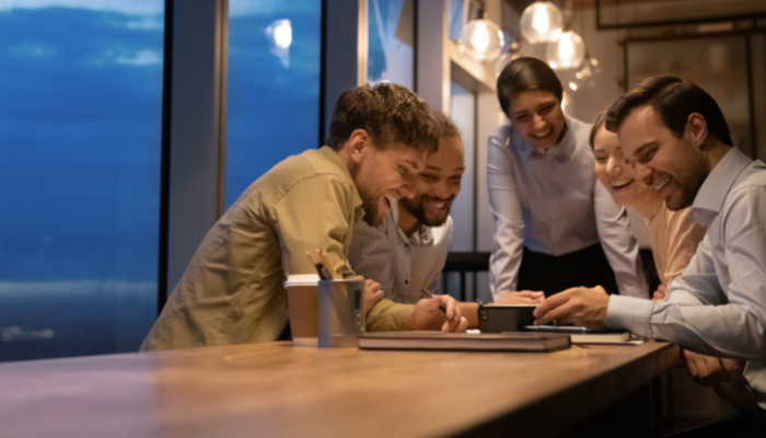Passionate team collaborating at a brightly lit table in the evening.