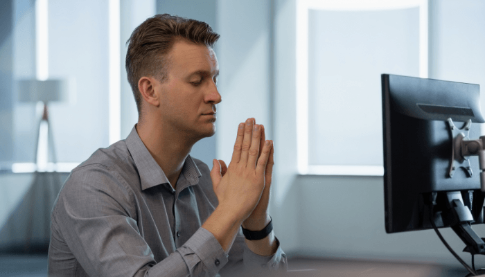 young male executive taking a mindfulness break at his desk