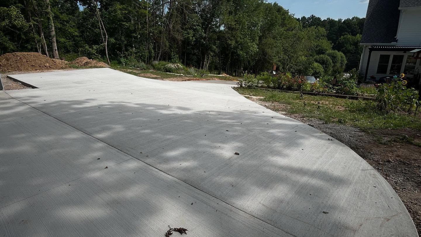 Covered porch with wet stamped concrete floor, wooden posts, and a white door on a gray house