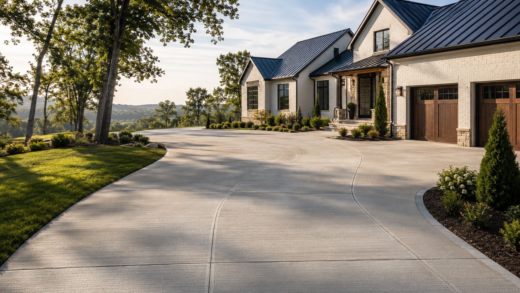 Luxurious suburban house with a wide curved concrete driveway and landscaped lawn at sunset