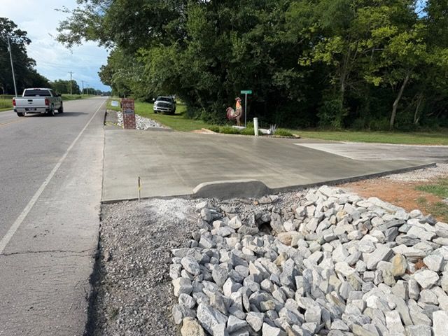 Gravel-lined curb ramp beside a road and sidewalk near trees and parked cars