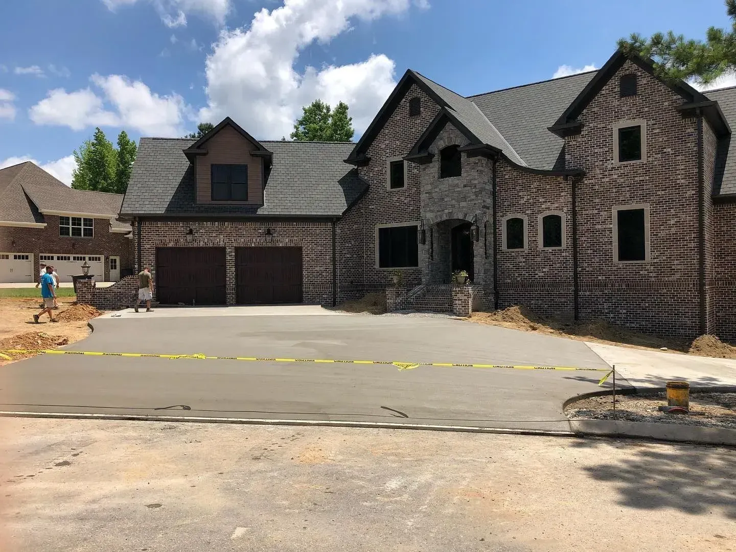 Partially built brick house with garage in a suburban neighborhood on a sunny day