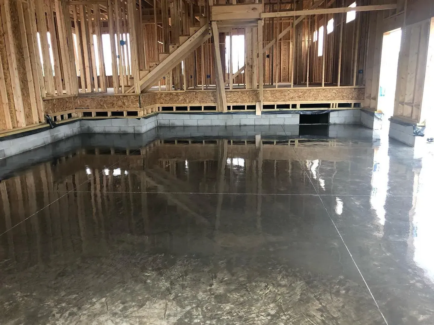 Flooded unfinished interior with exposed wooden framing and standing water on the floor