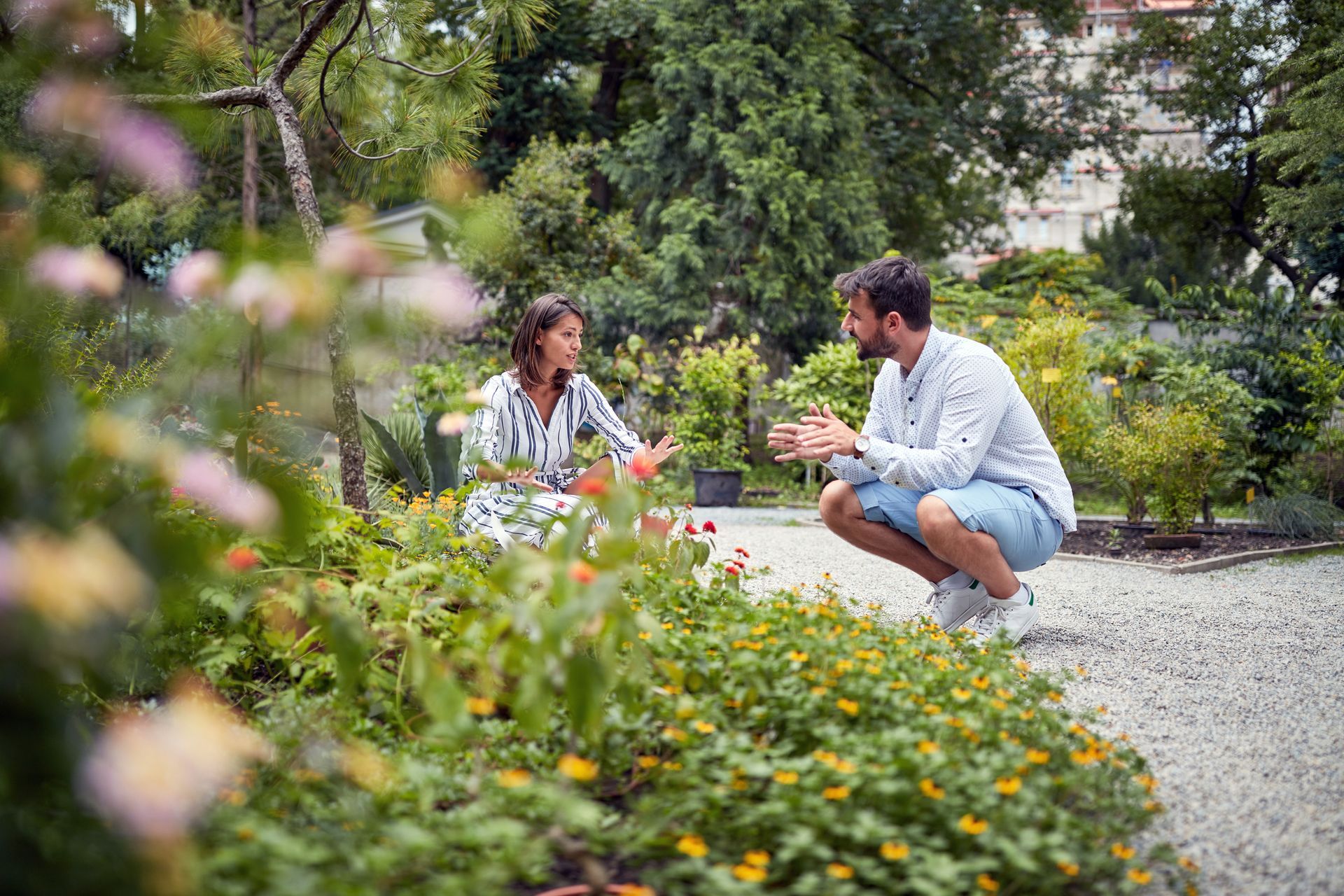 Woman and men discussing and preparing to working exterior in garden. Woman and men discussing and preparing to working exterior in garden.