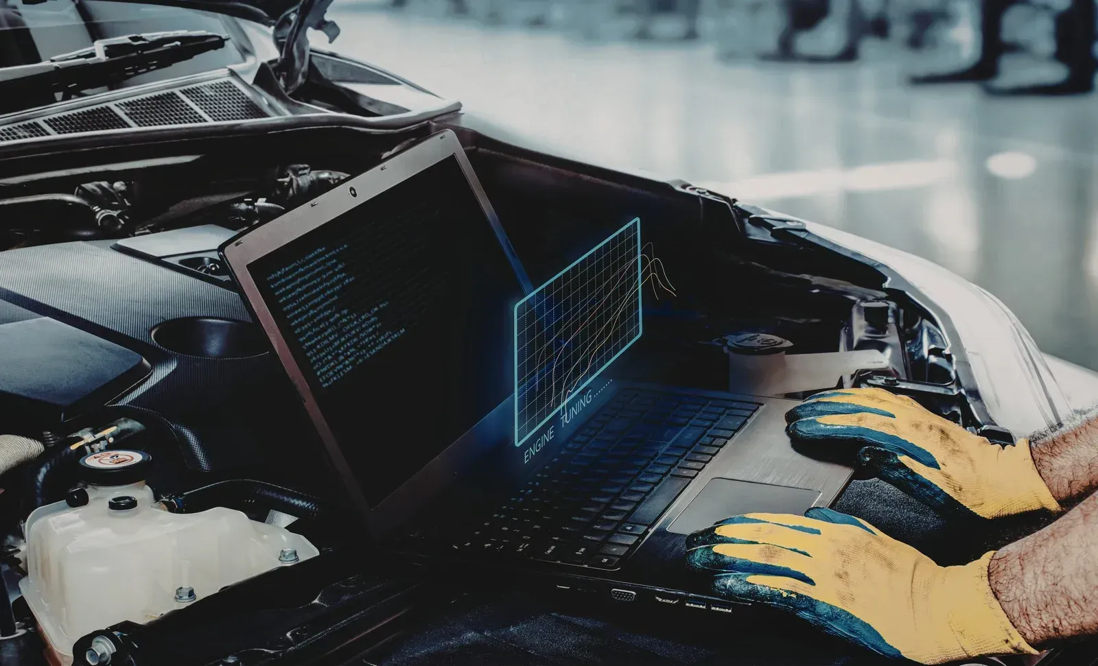 Two open laptops in a car with gloved hands working on them, suggesting in-vehicle tech repair