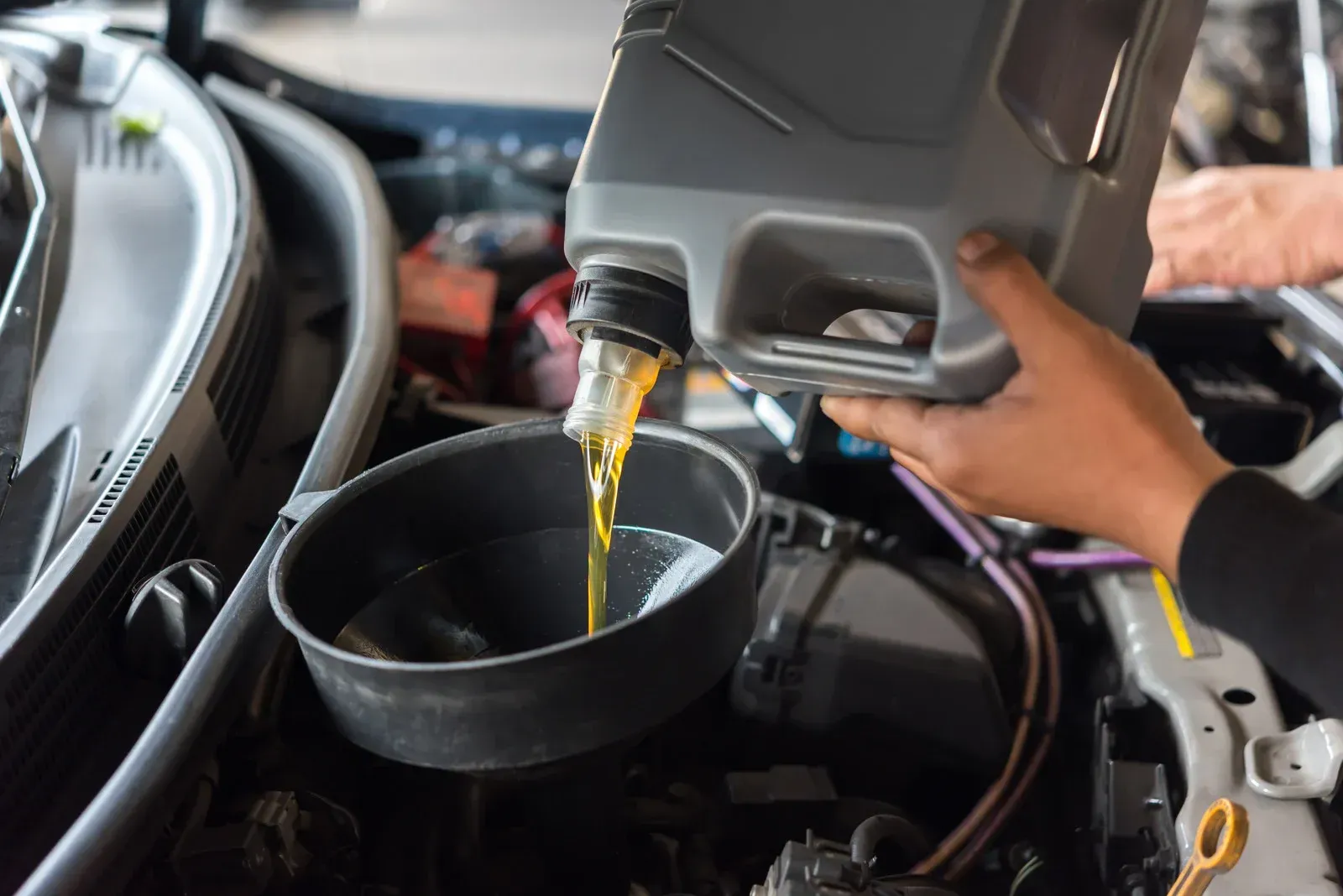 Pouring oil into a car engine during maintenance