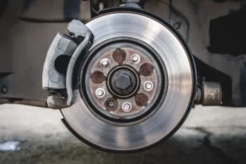 Close-up of a car brake rotor and caliper with wheel removed