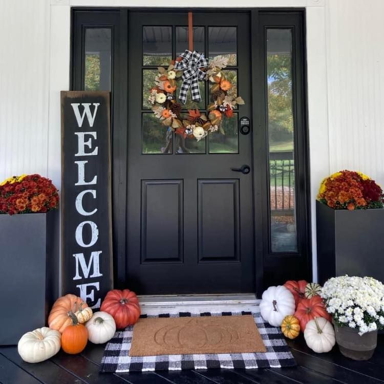 A black door with a welcome sign in front of it