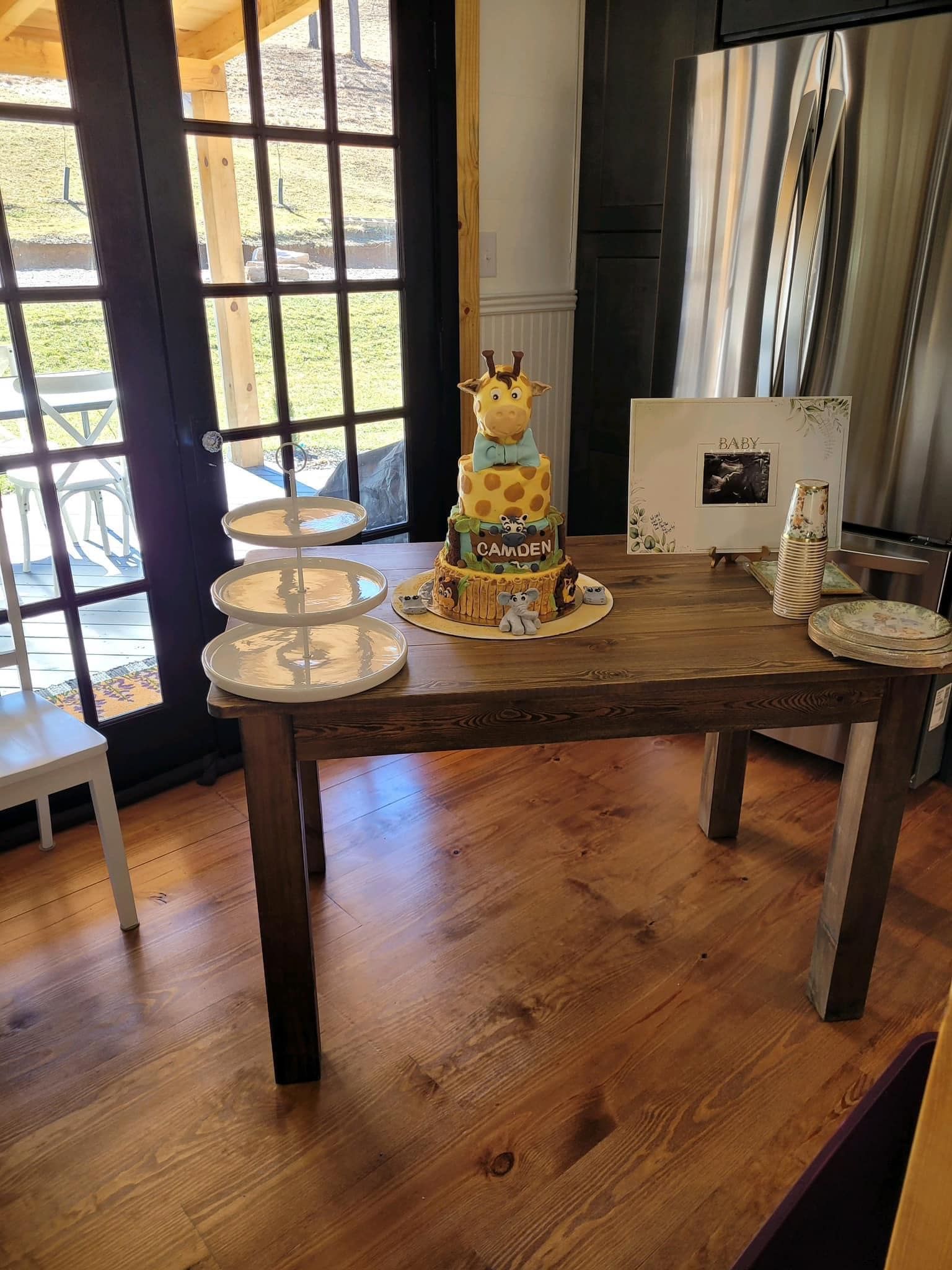 A giraffe cake is sitting on top of a wooden table.