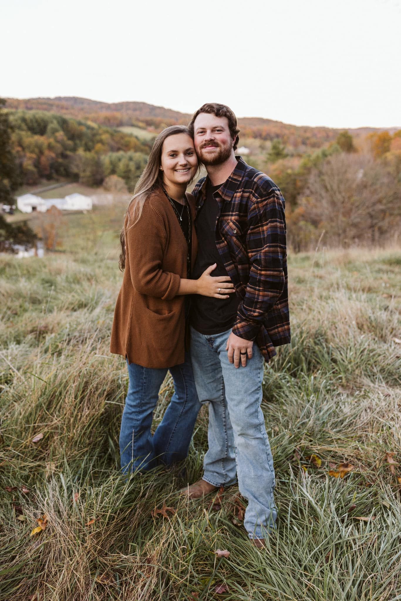 A man and a woman are standing next to each other in a field.