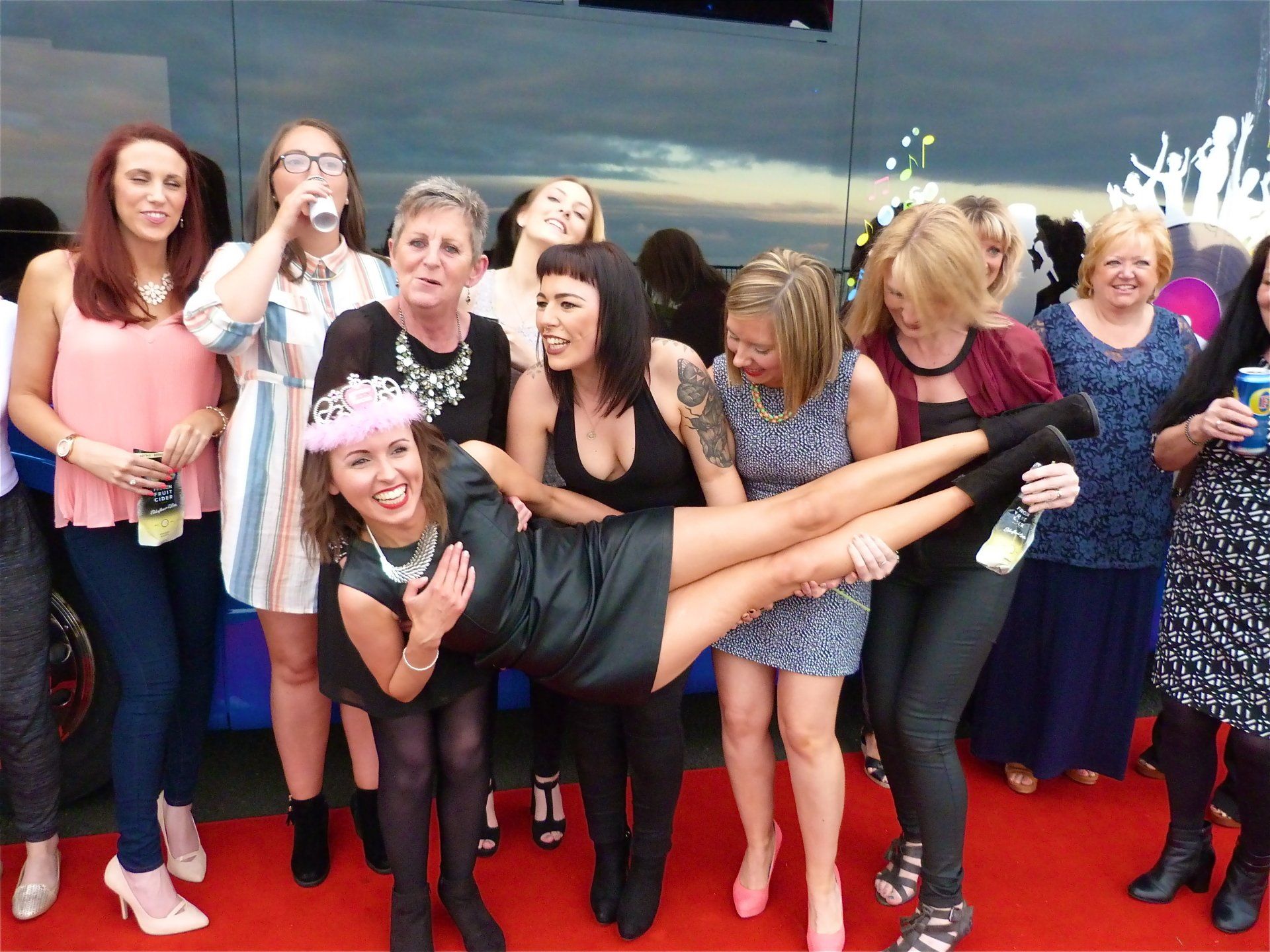 A group of women are posing for a picture on a red carpet.