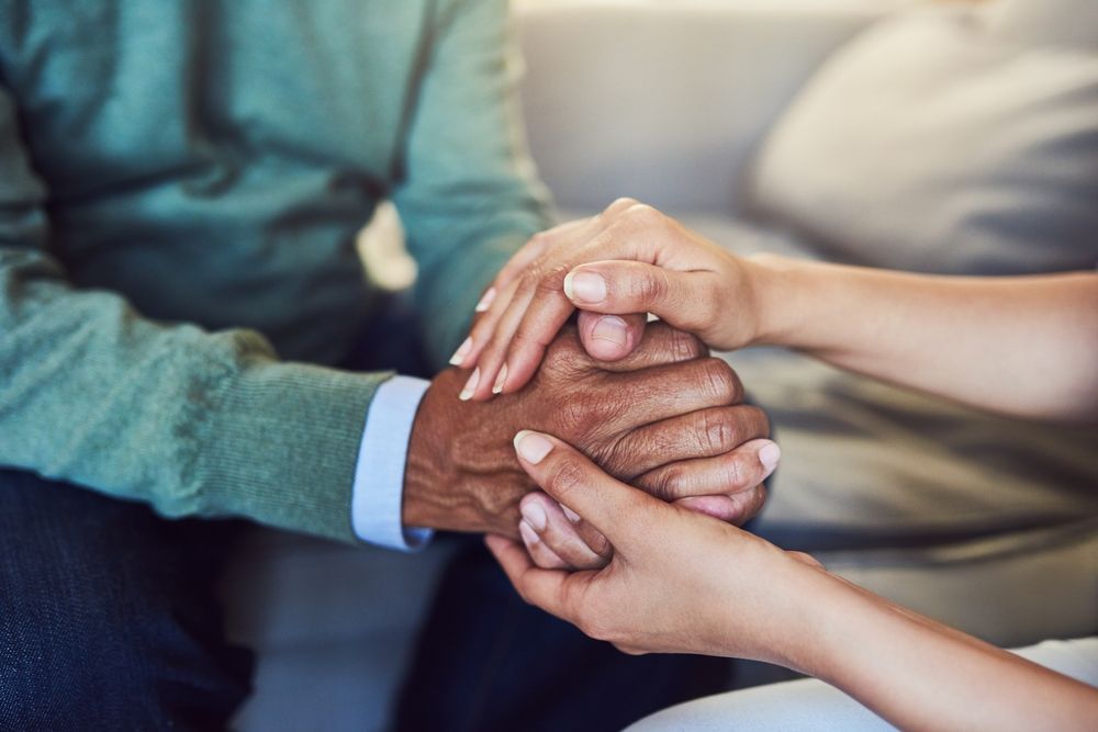 Several hands stacked together in a group gesture of support and unity