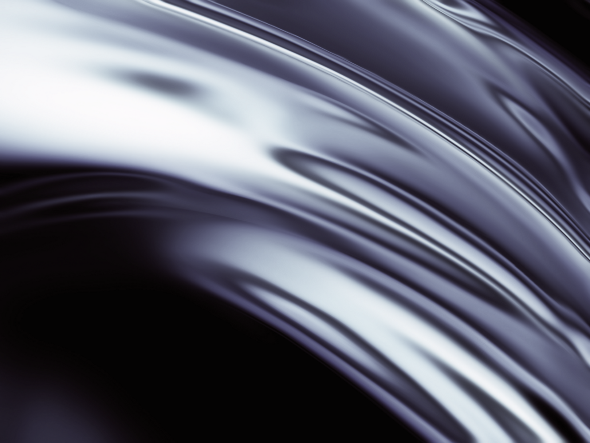 A close up of a shiny metal surface on a black background