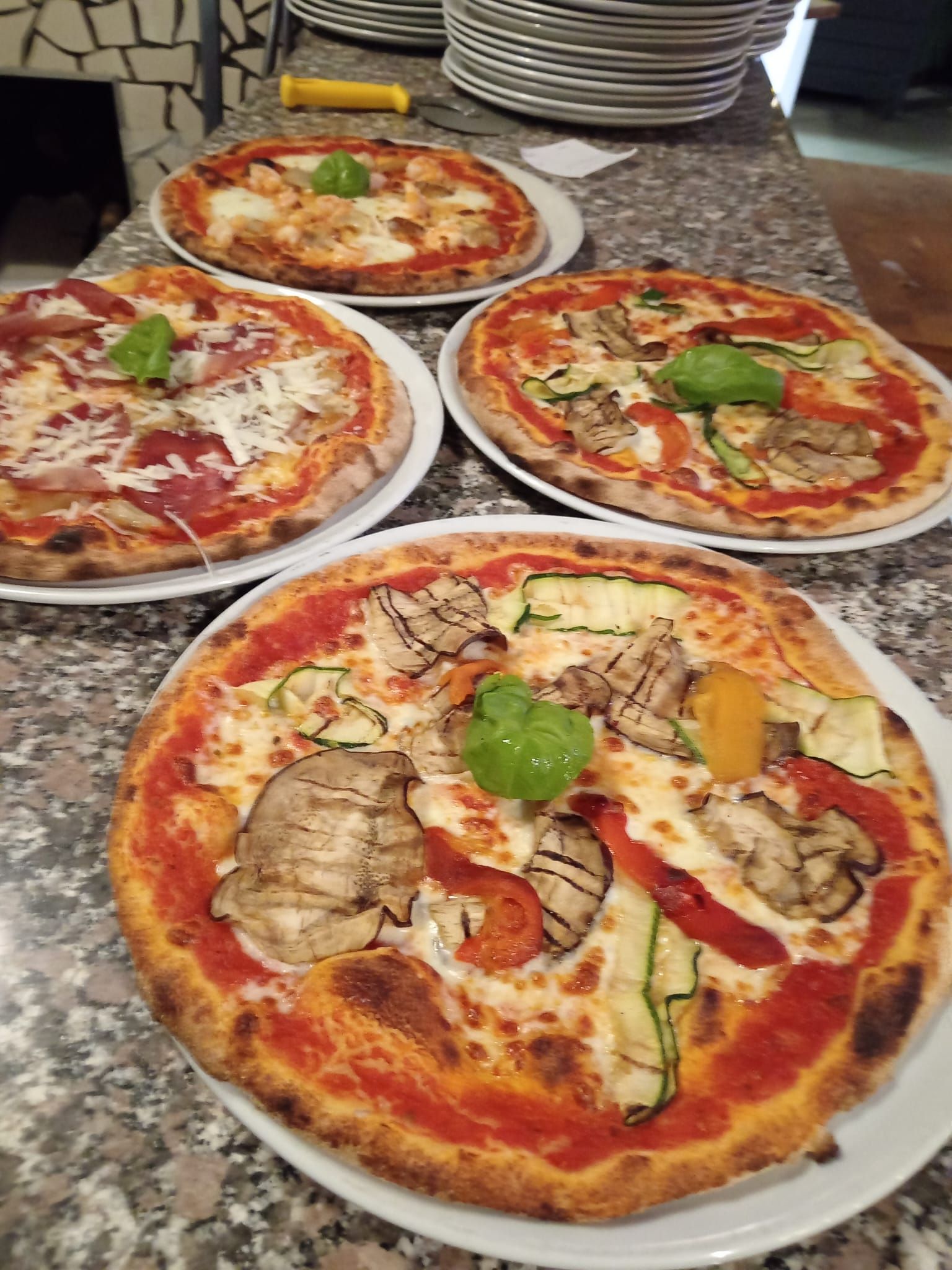 tavolo in marmo con tre pizze della pizzeria La Bottiglieria di Legnano