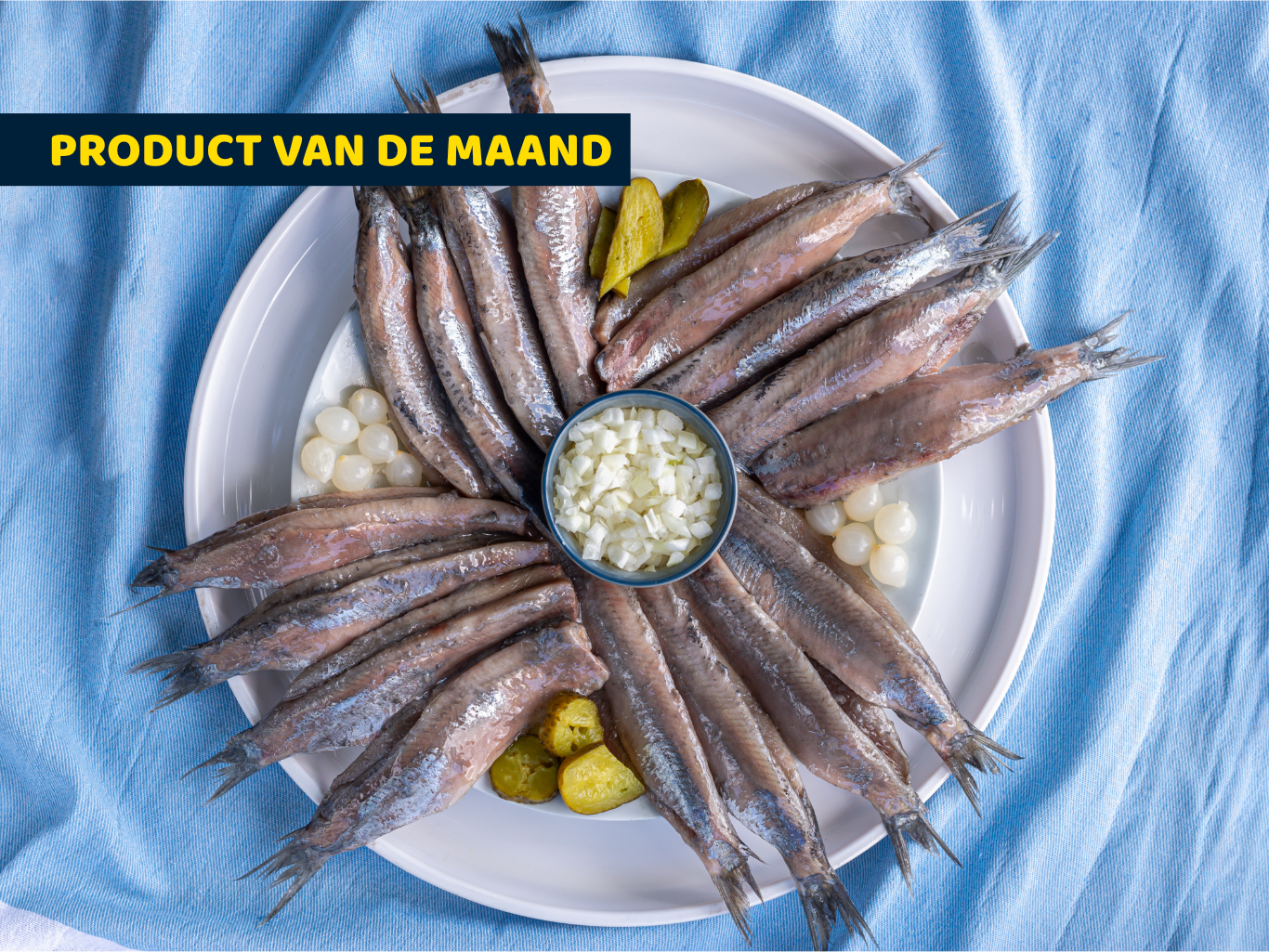 Bord met gemarineerde garnalenspies en gemarineerde zalmspies met groentes en citroen. Op de achtergrond staat een barbecue en in beeld staat de tekst: Vis op de BBQ.