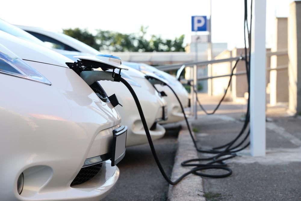 A Row of Electric Cars Are Being Charged at A Charging Station — Lismore Car Repairs in Lismore, NSW