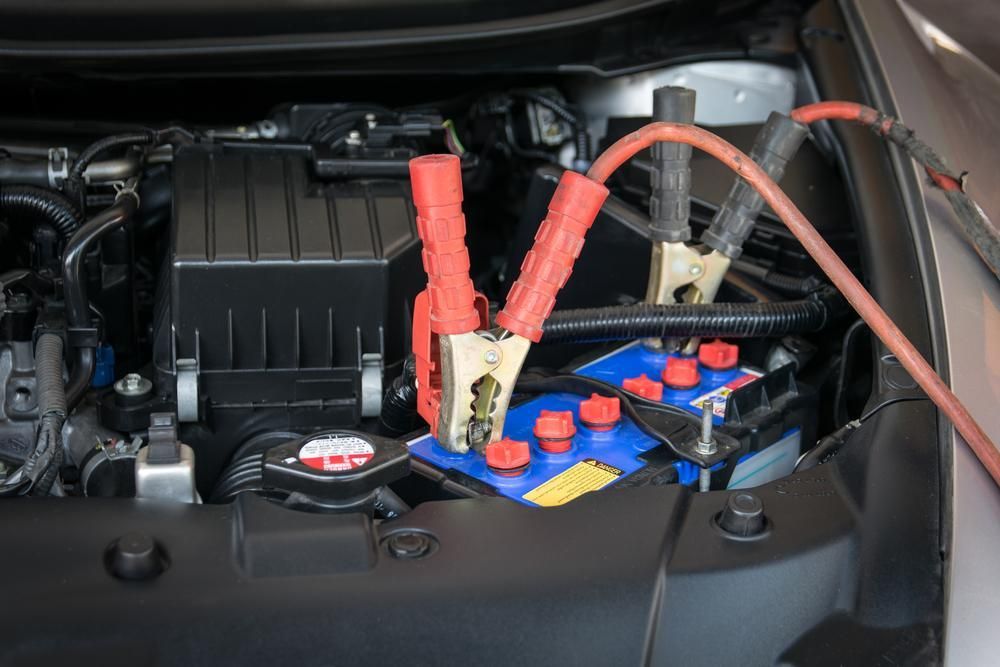 A Car Battery Is Being Charged with Jumper Cables — Lismore Car Repairs in Lismore, NSW