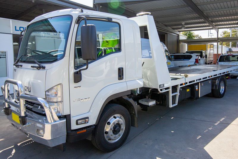 A White Tow Truck Is Parked in A Parking Lot — Lismore Car Repairs in Lismore, NSW