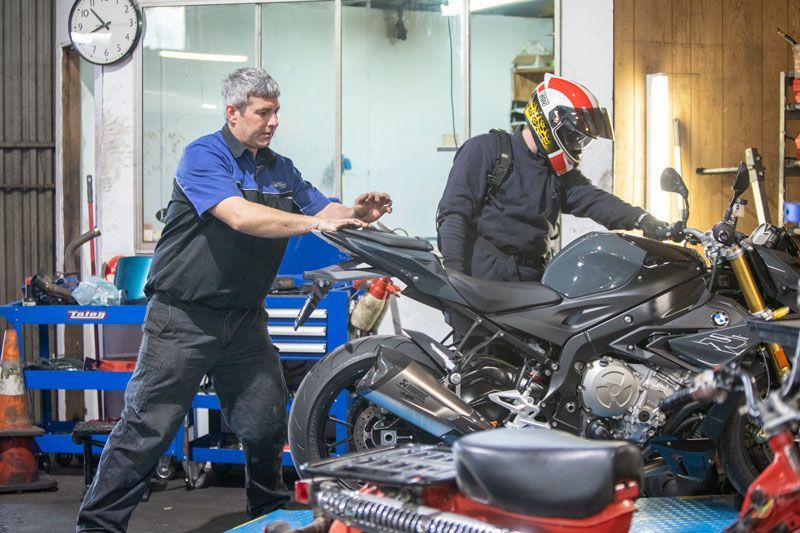 Two Men Are Working on A Motorcycle in A Garage — Lismore Car Repairs in Lismore, NSW