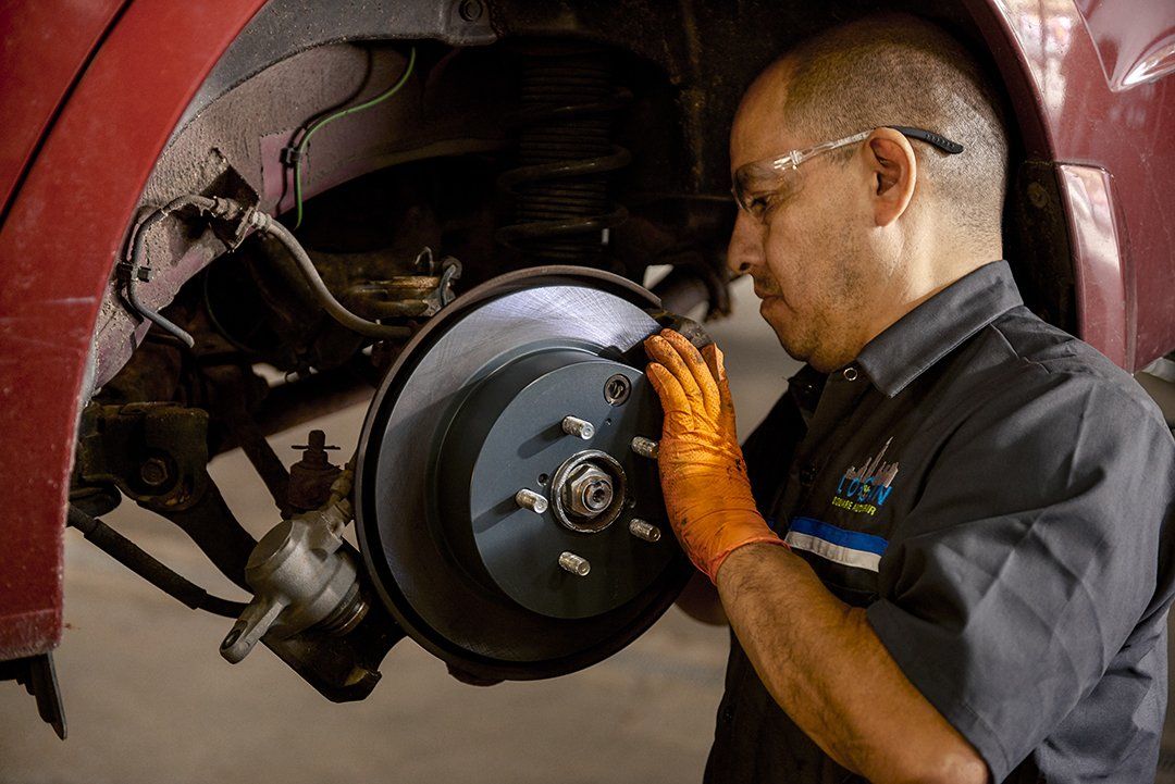 A man is working on the brake system of a car.
