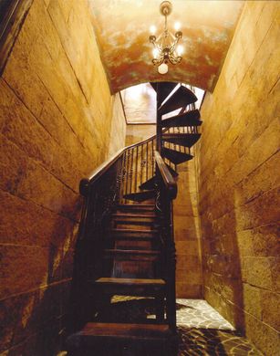 A spiral staircase with a chandelier hanging from the ceiling