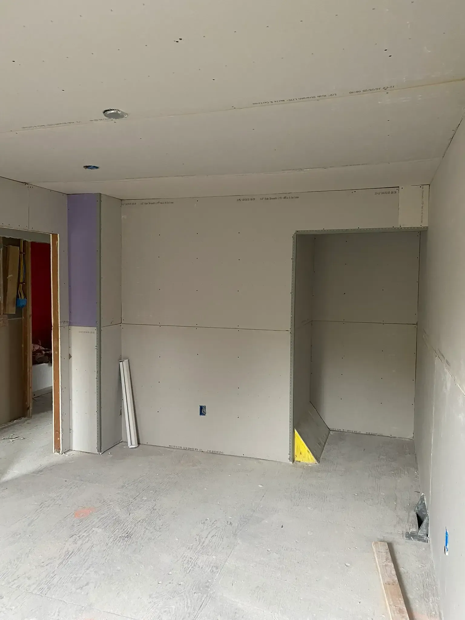 Drywall sheets staged against a wall before installation in a home renovation project in Drexel Hill, PA.