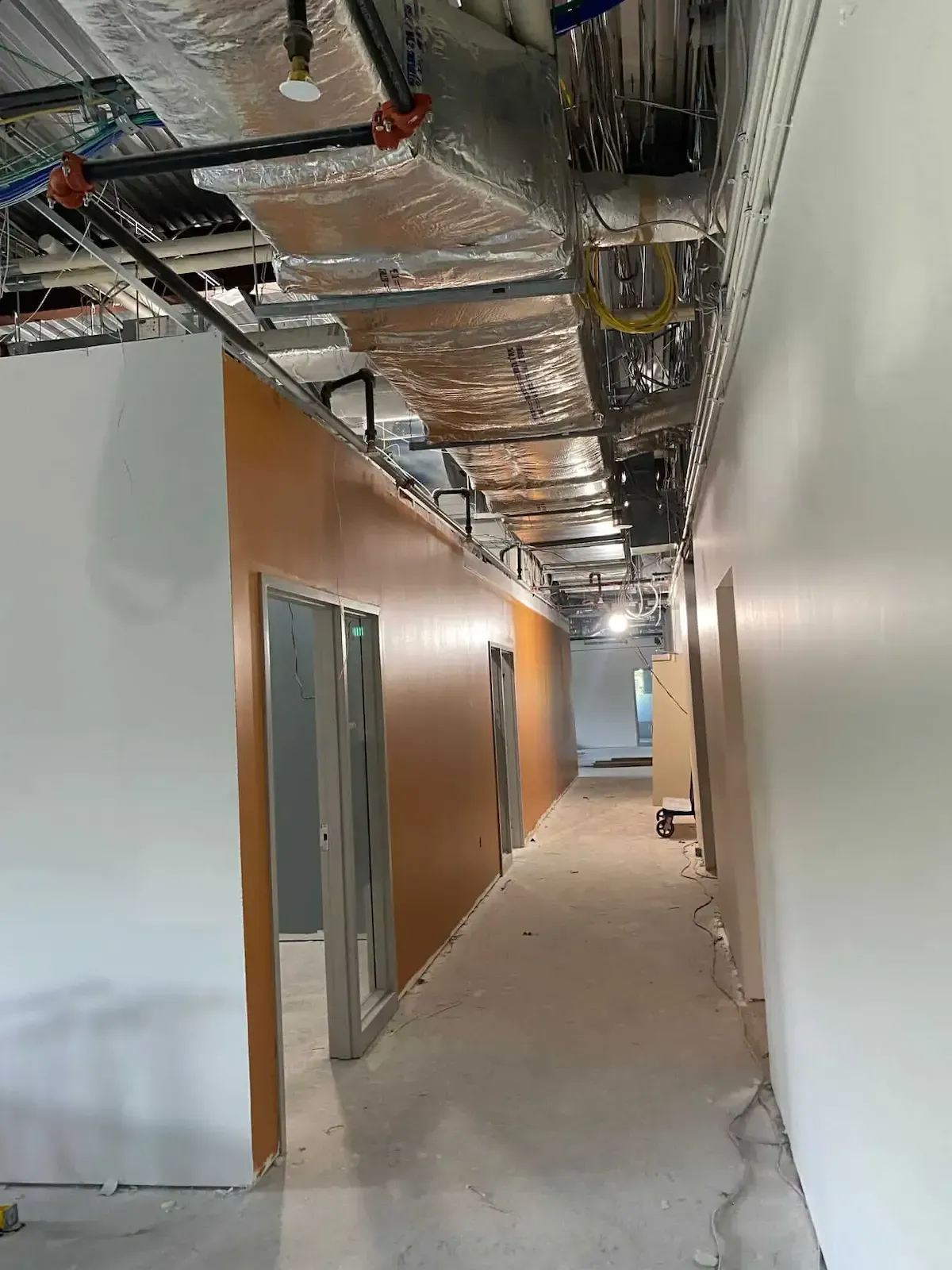 Pottstown PA office painting – long hallway with orange and white walls under construction by Oasis Painting & Drywall.