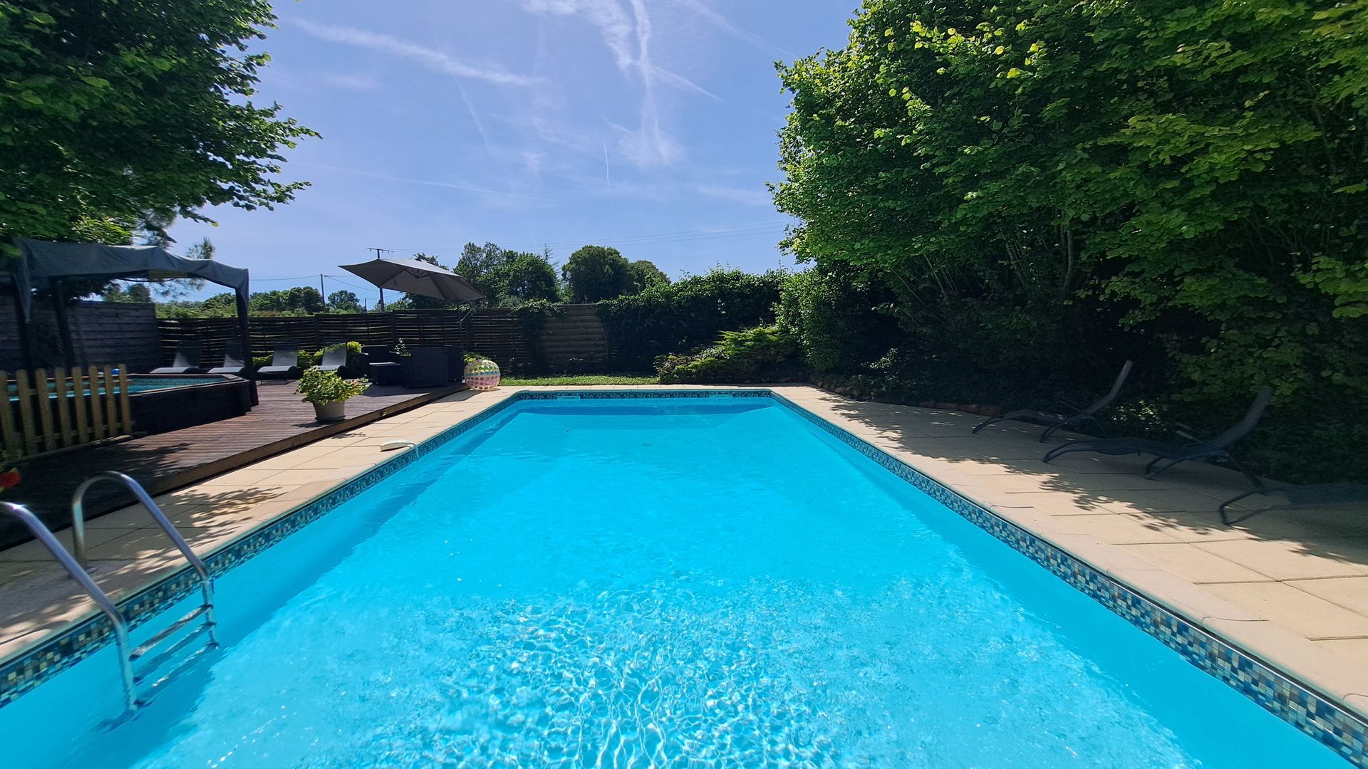 10m by 5m swimming pool surrounded by stone slab terrace