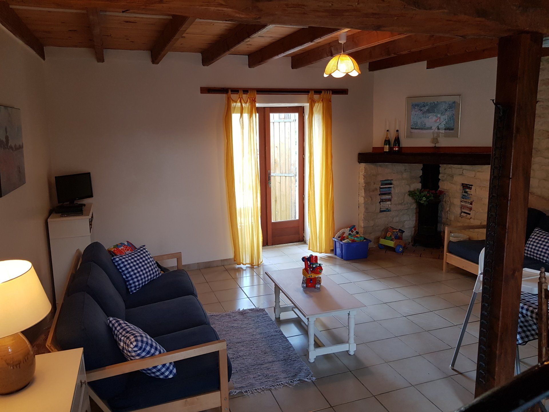 sitting room with tiled floor and yellow voile curtains