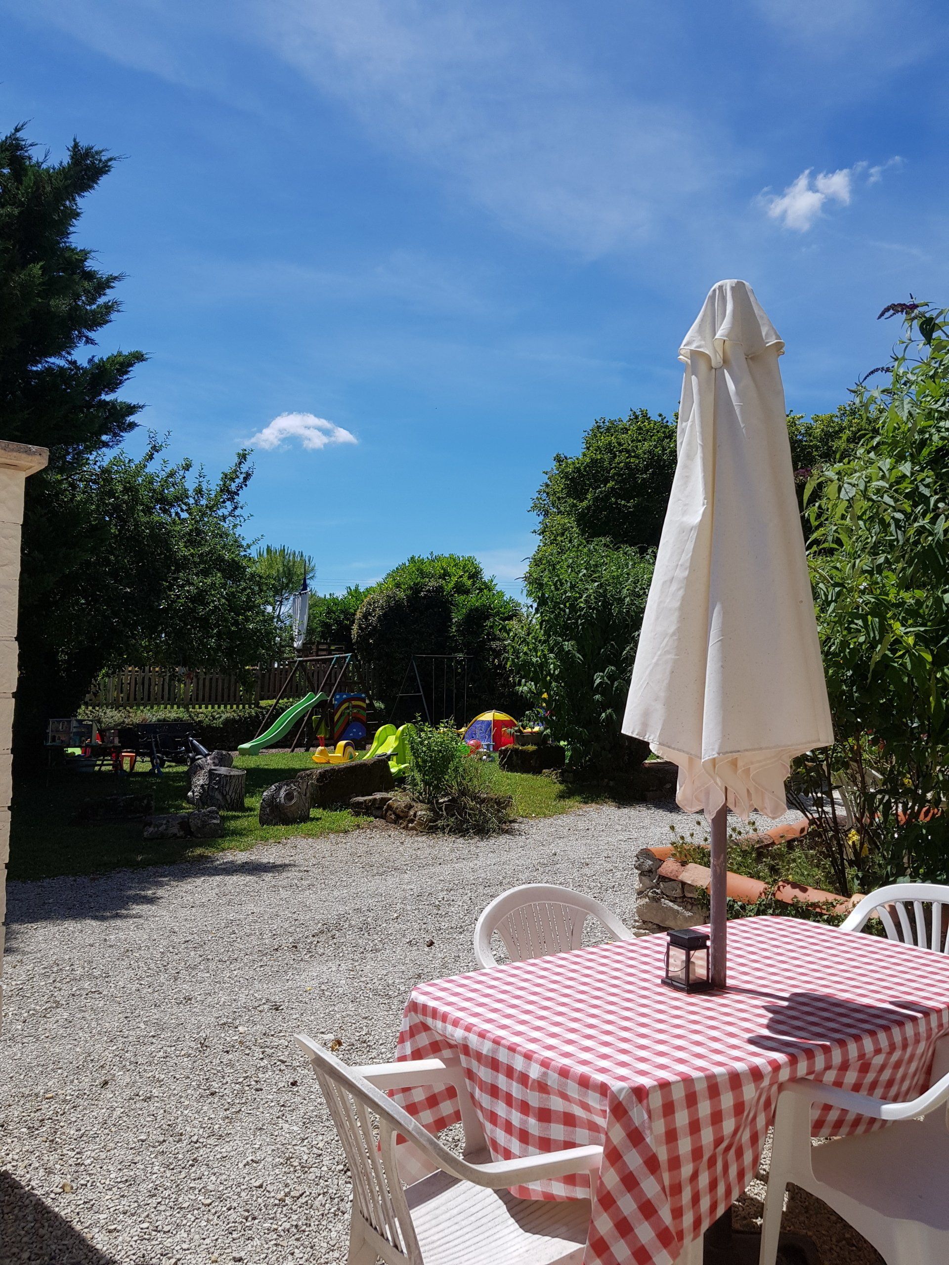 white plastic garden table and chairs with red and white checked table cloth