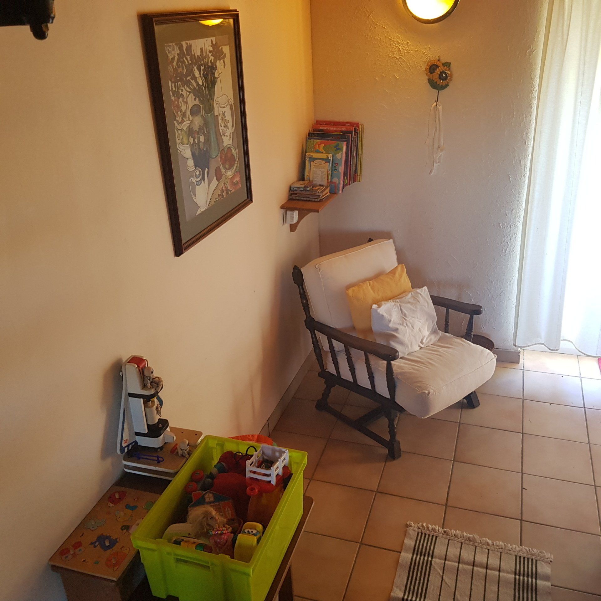 box of childrens toys and an armchair with cream cusions
