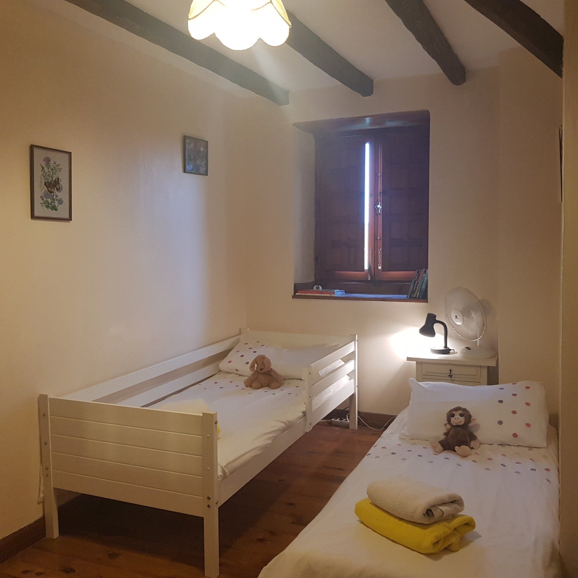 a childrens bedroom with white ikea bed and rollaway bed next to it, both with white bedlinen