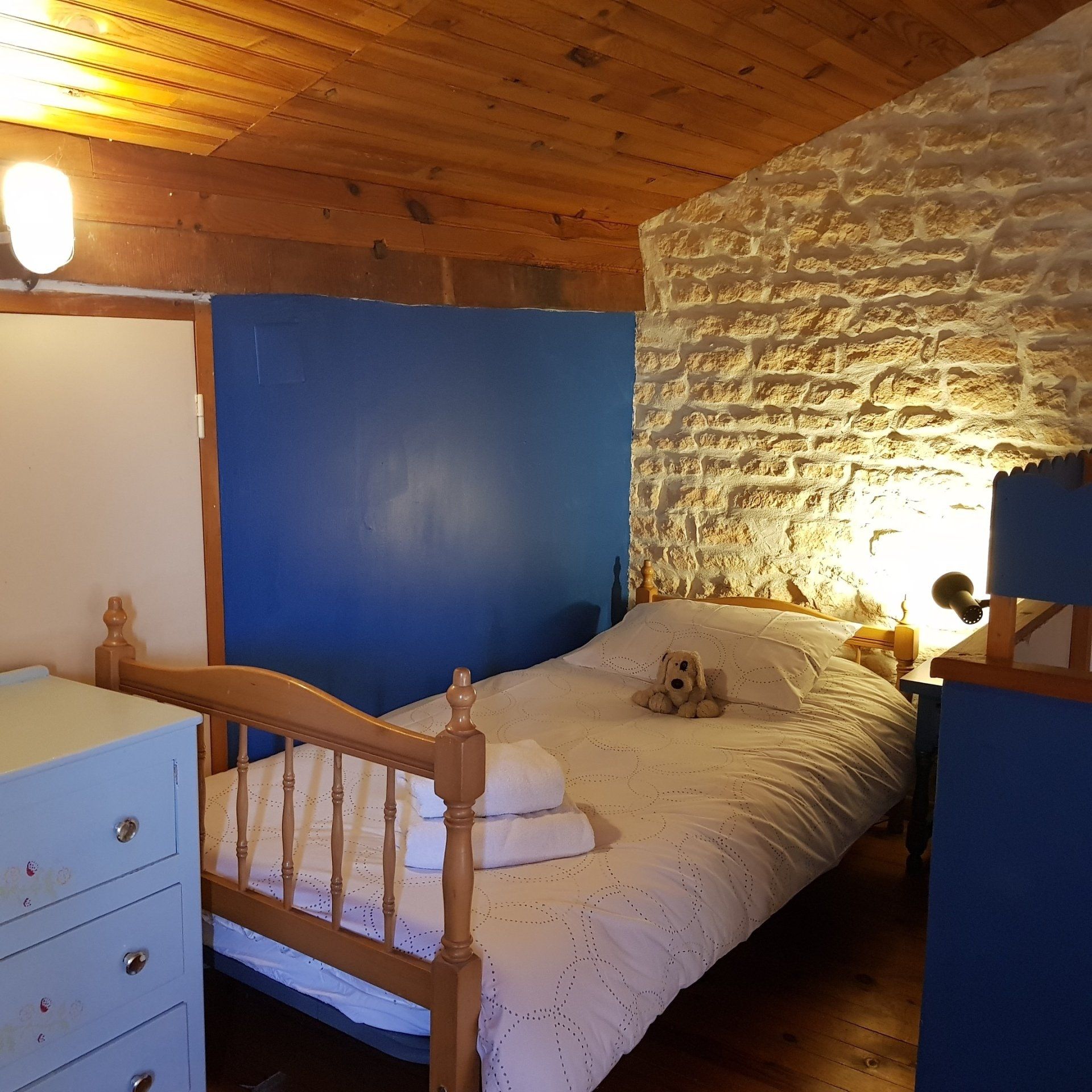 single bed in an attic room with blue walls