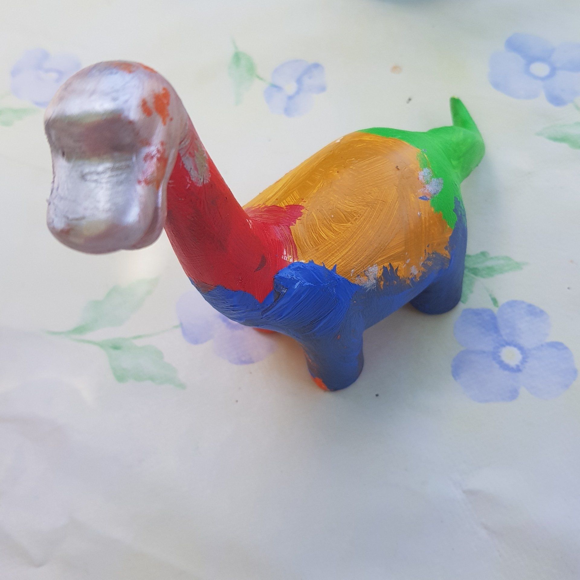een kleurrijk beschilderde aardewerken dinosaurus
