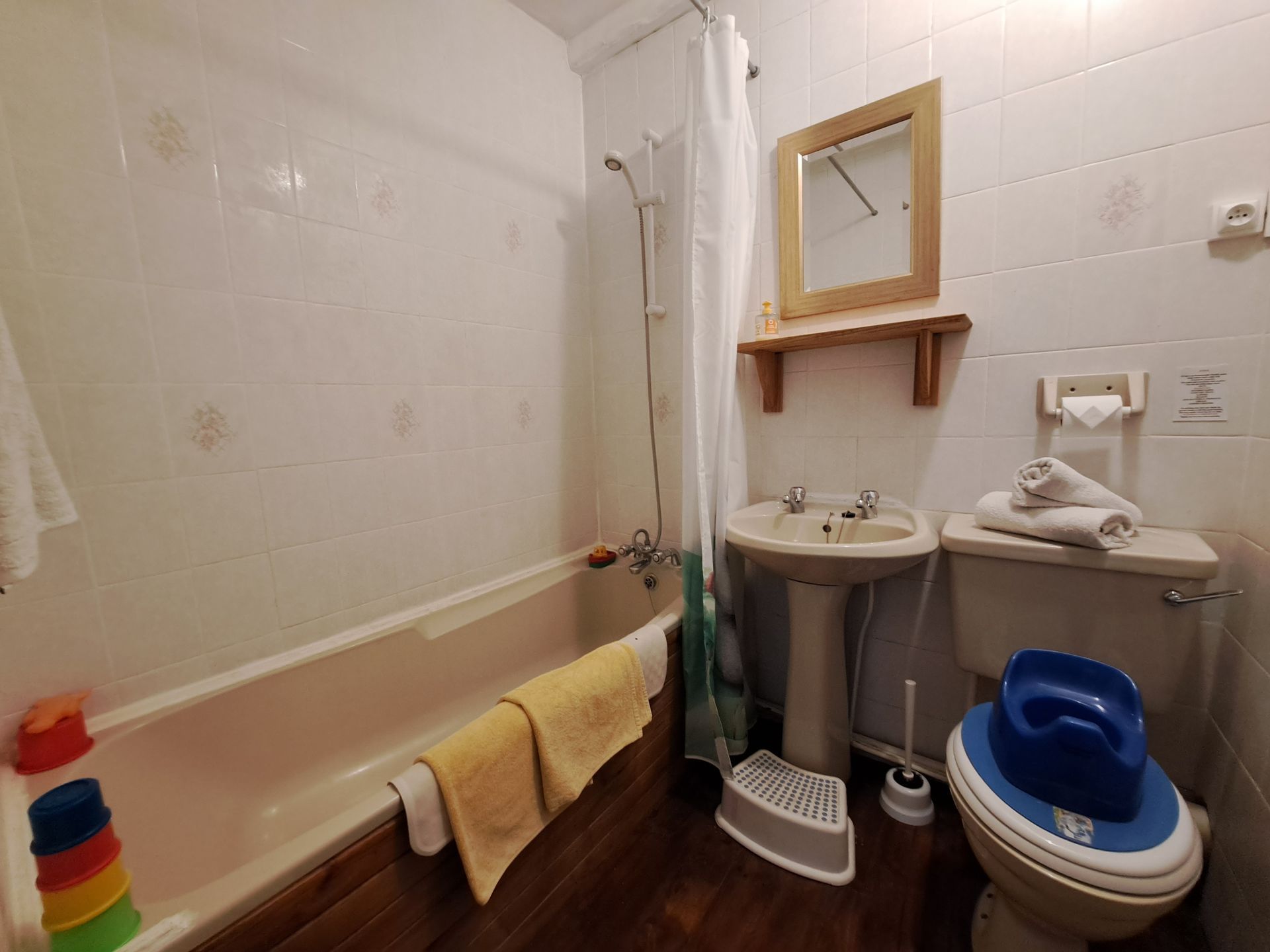 salle de bain crème avec pot et marchepied pour tout-petit